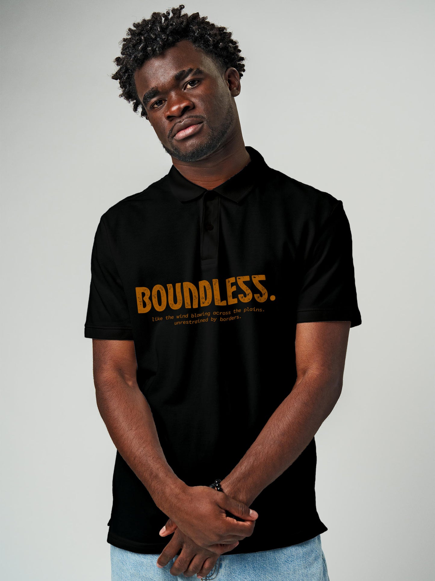 Model wearing Men's Black Polo T-shirt with 'Free & Boundless' design, offering effortless style and premium comfort