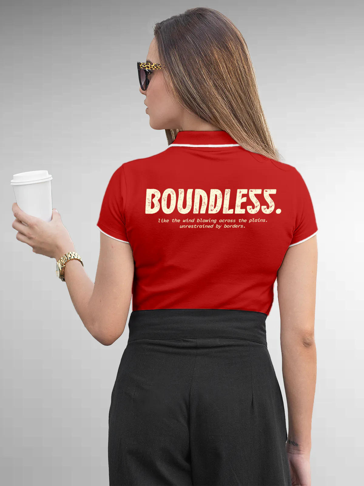 Model wearing Women's Red Collar T-shirt with a big, bold 'Boundless' design printed on the back, along with an insiprational text