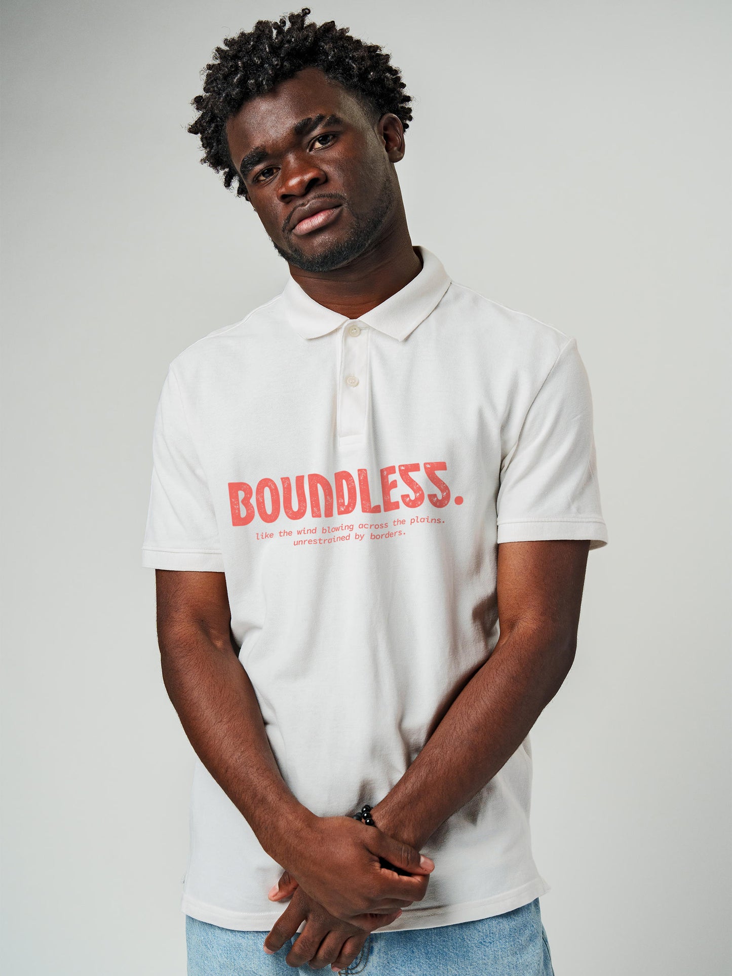 Model wearing Men's White Polo T-shirt with 'Free & Boundless' design, offering effortless style and premium comfort