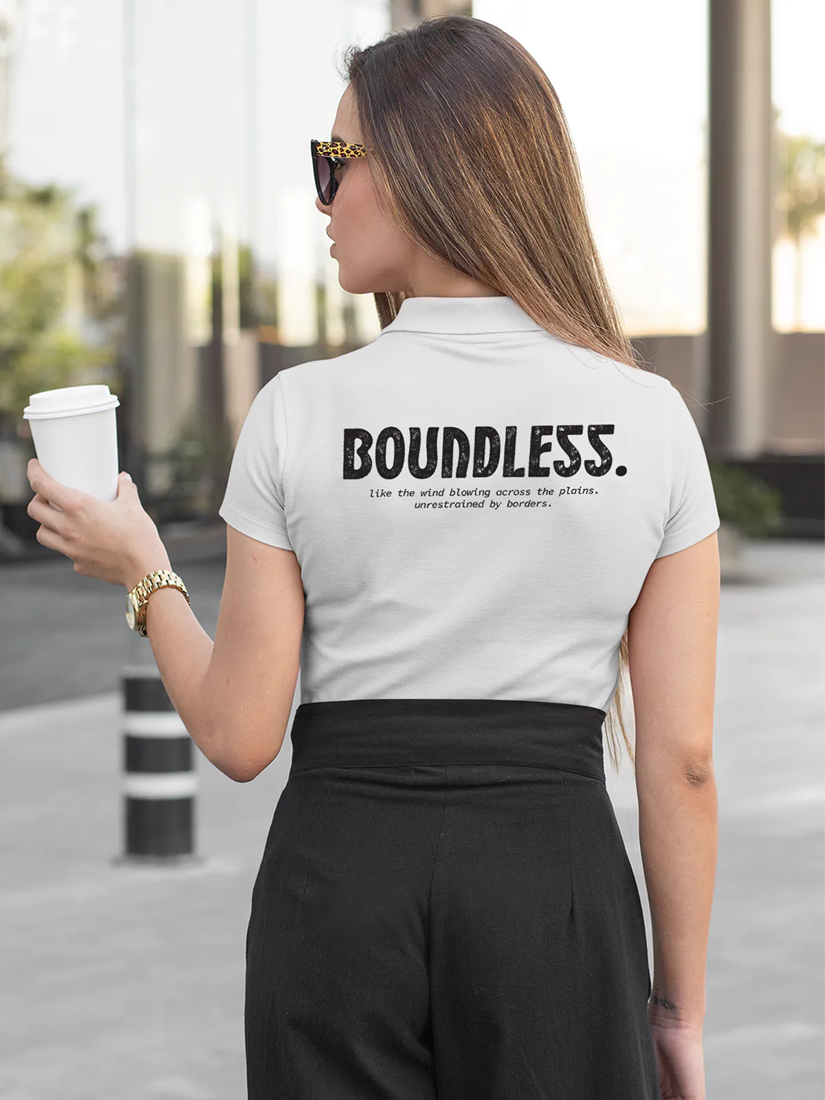 Model wearing Women's White Collar T-shirt with a big, bold 'Boundless' design printed on the back, along with an insiprational text