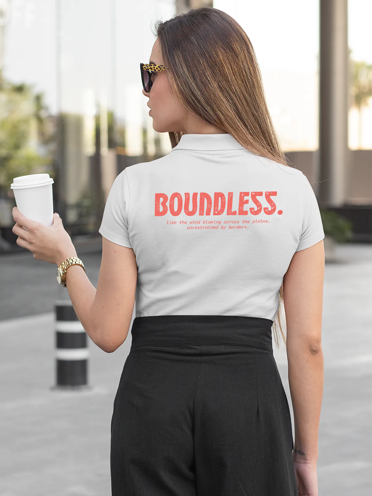 Model wearing Women's White Collar T-shirt with a big, bold 'Boundless' design printed on the back, along with an insiprational text