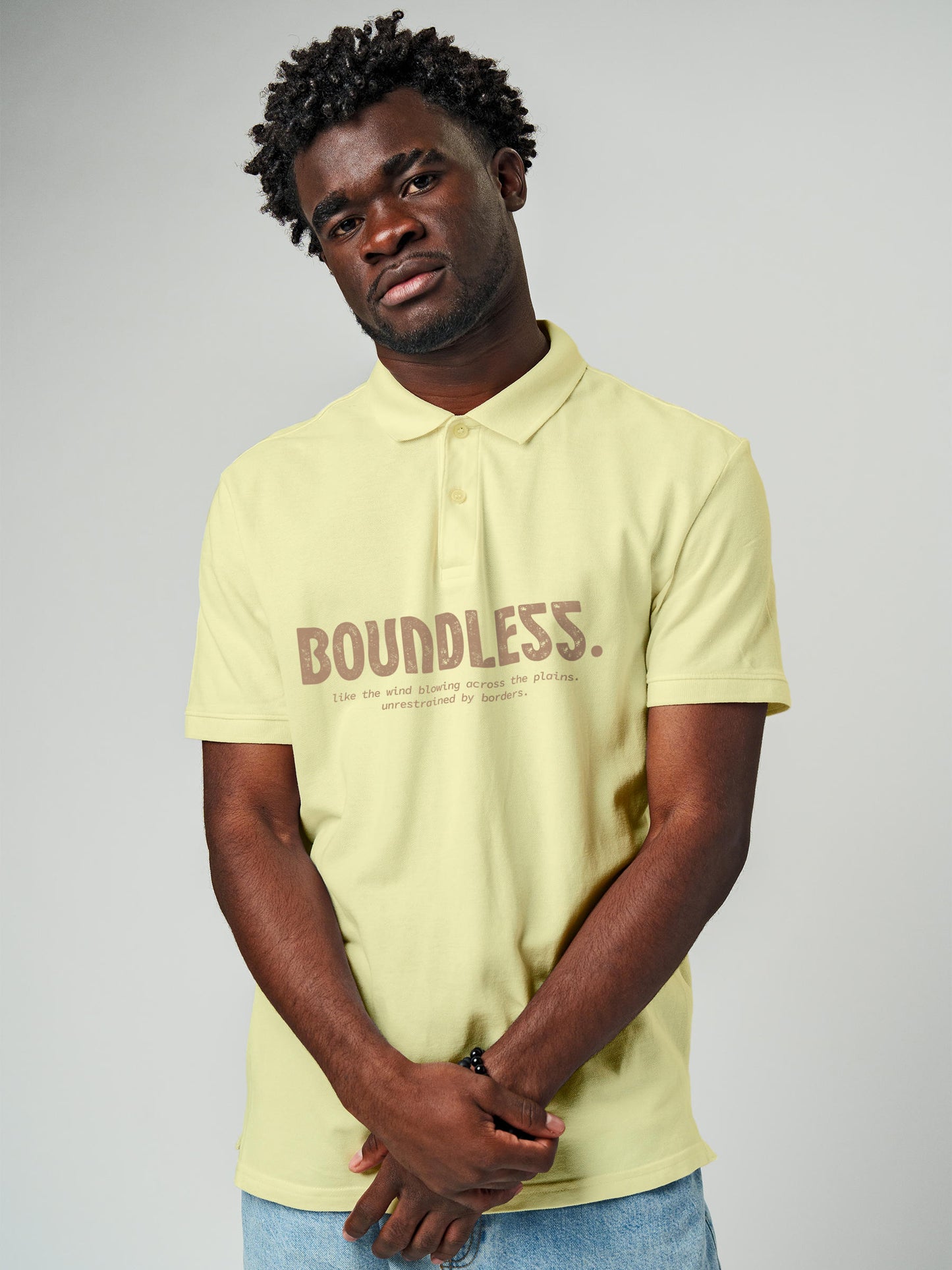 Model wearing Men's Yellow Polo T-shirt with 'Free & Boundless' design, offering effortless style and premium comfort