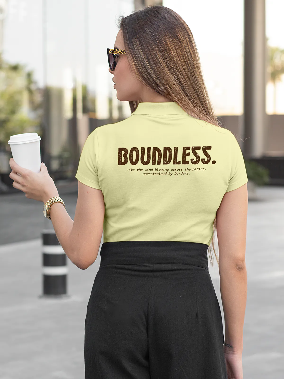 Fighterhero Polos: Model wearing Women's Yellow Polo T-shirt with 'Free & Boundless' design