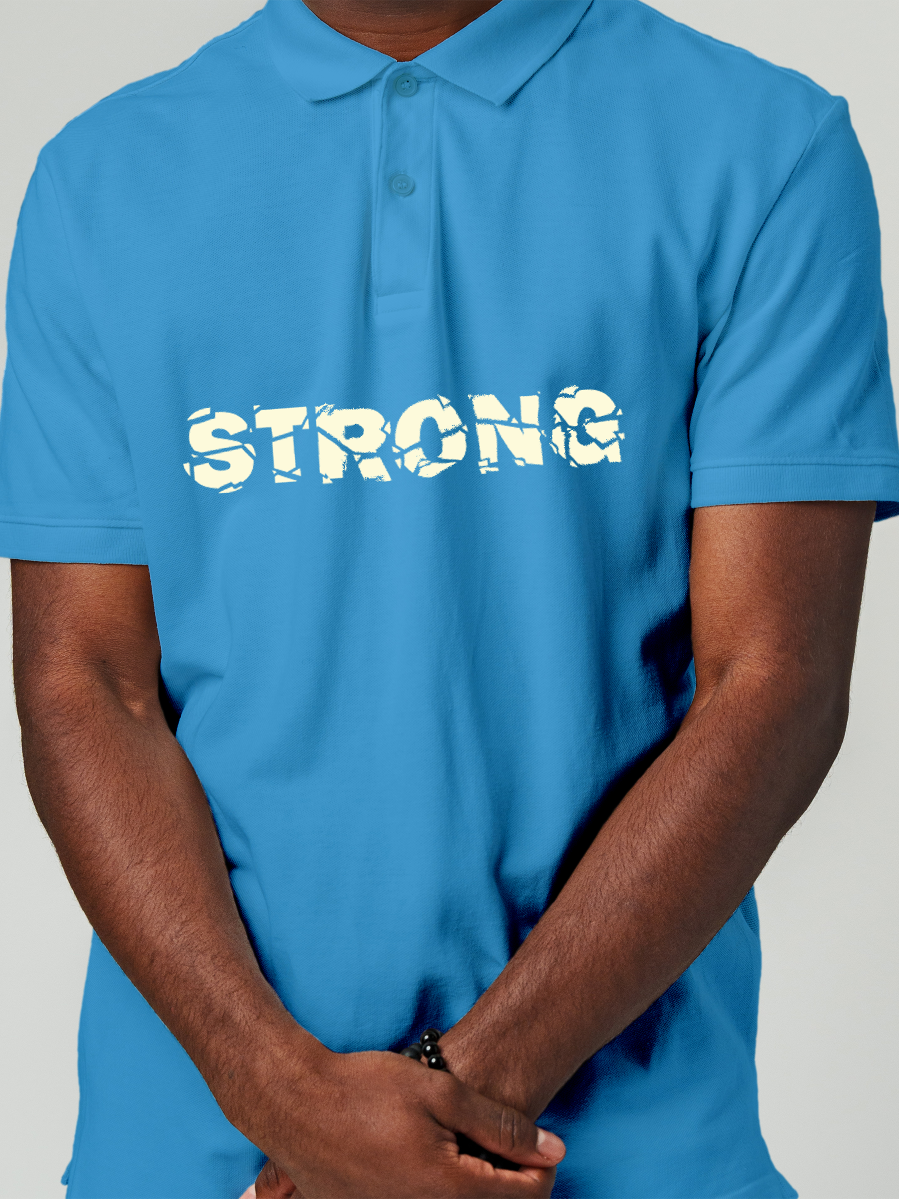 Close up of 'Strong' design on Men's Blue Polo T-shirt, highlighting intricate details and vibrant print.