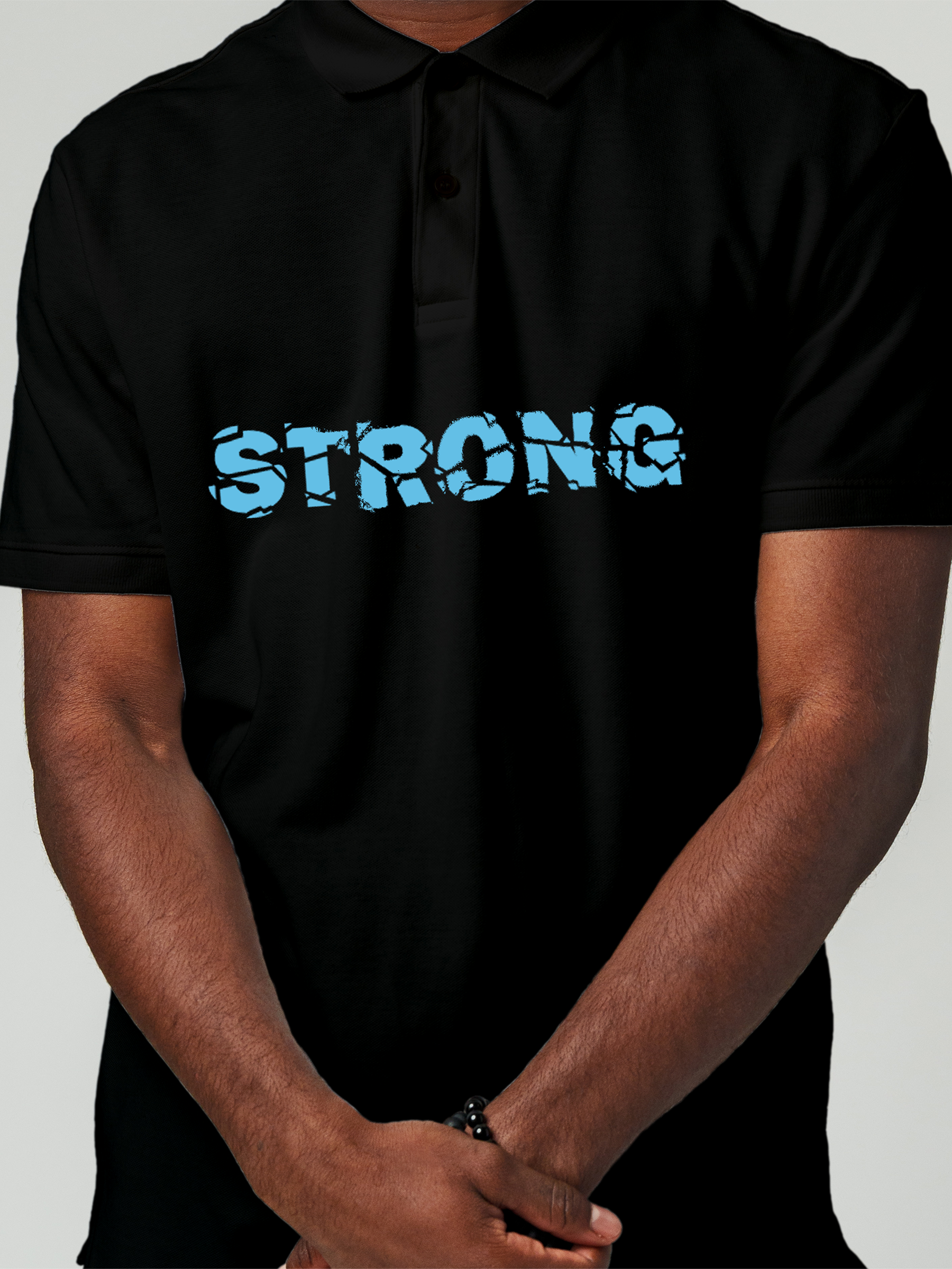 Close up of 'Strong' design on Men's Black Polo T-shirt, highlighting intricate details and vibrant print.