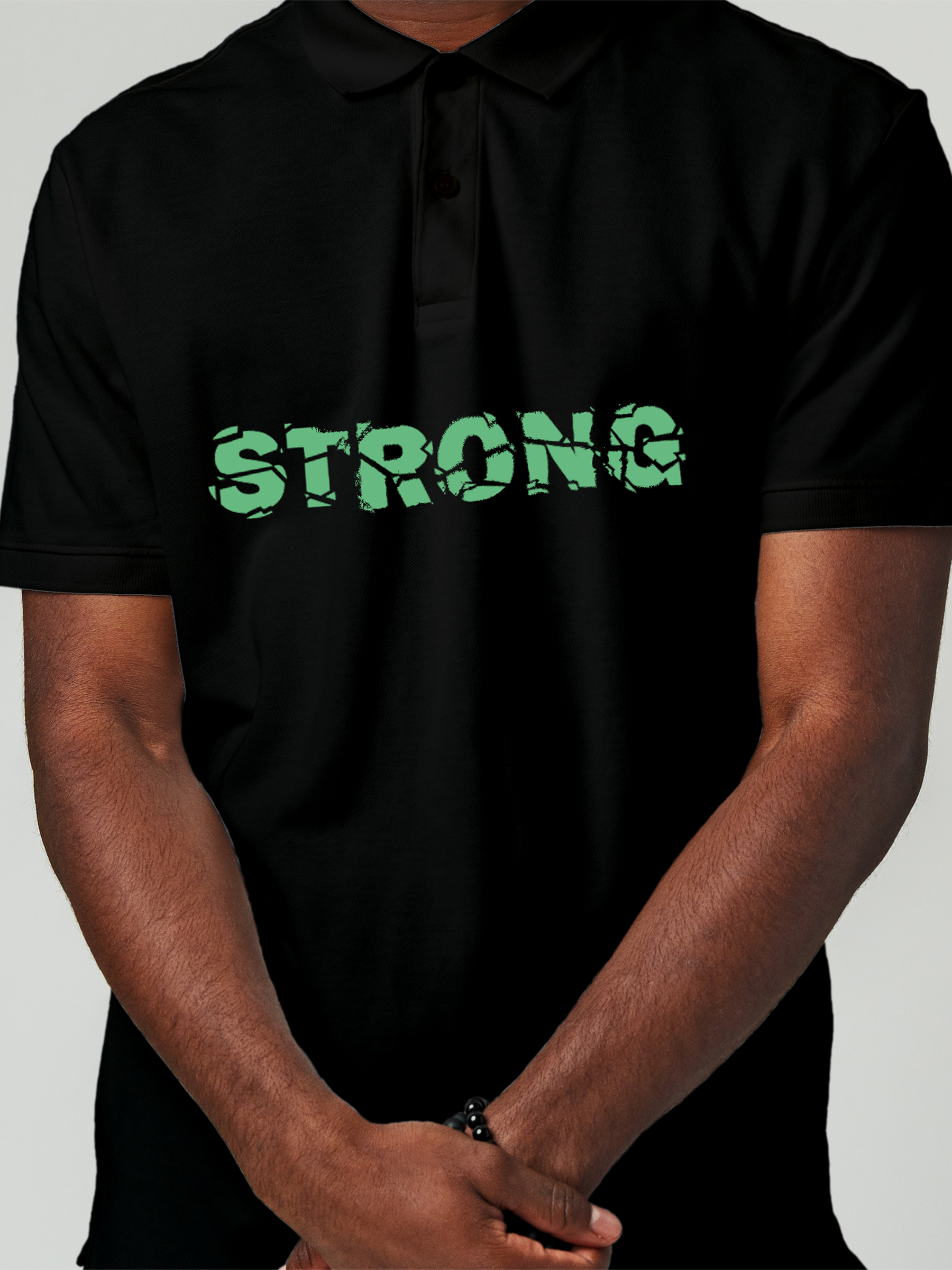 Close up of 'Strong' design on Men's Black Polo T-shirt, highlighting intricate details and vibrant print.