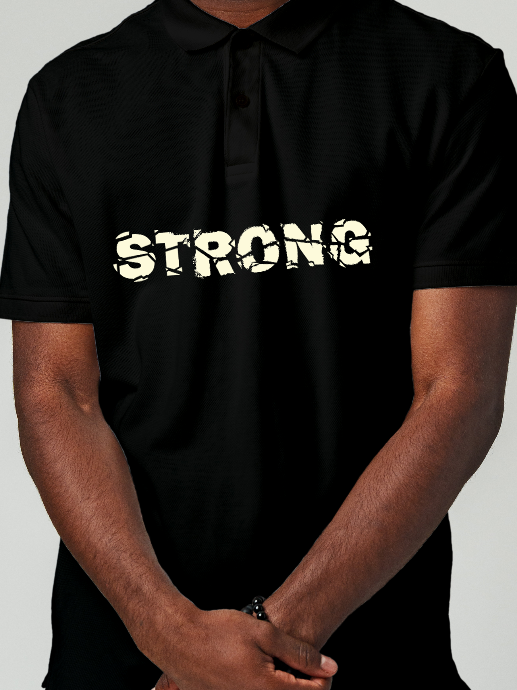 Close up of 'Strong' design on Men's Black Polo T-shirt, highlighting intricate details and vibrant print.