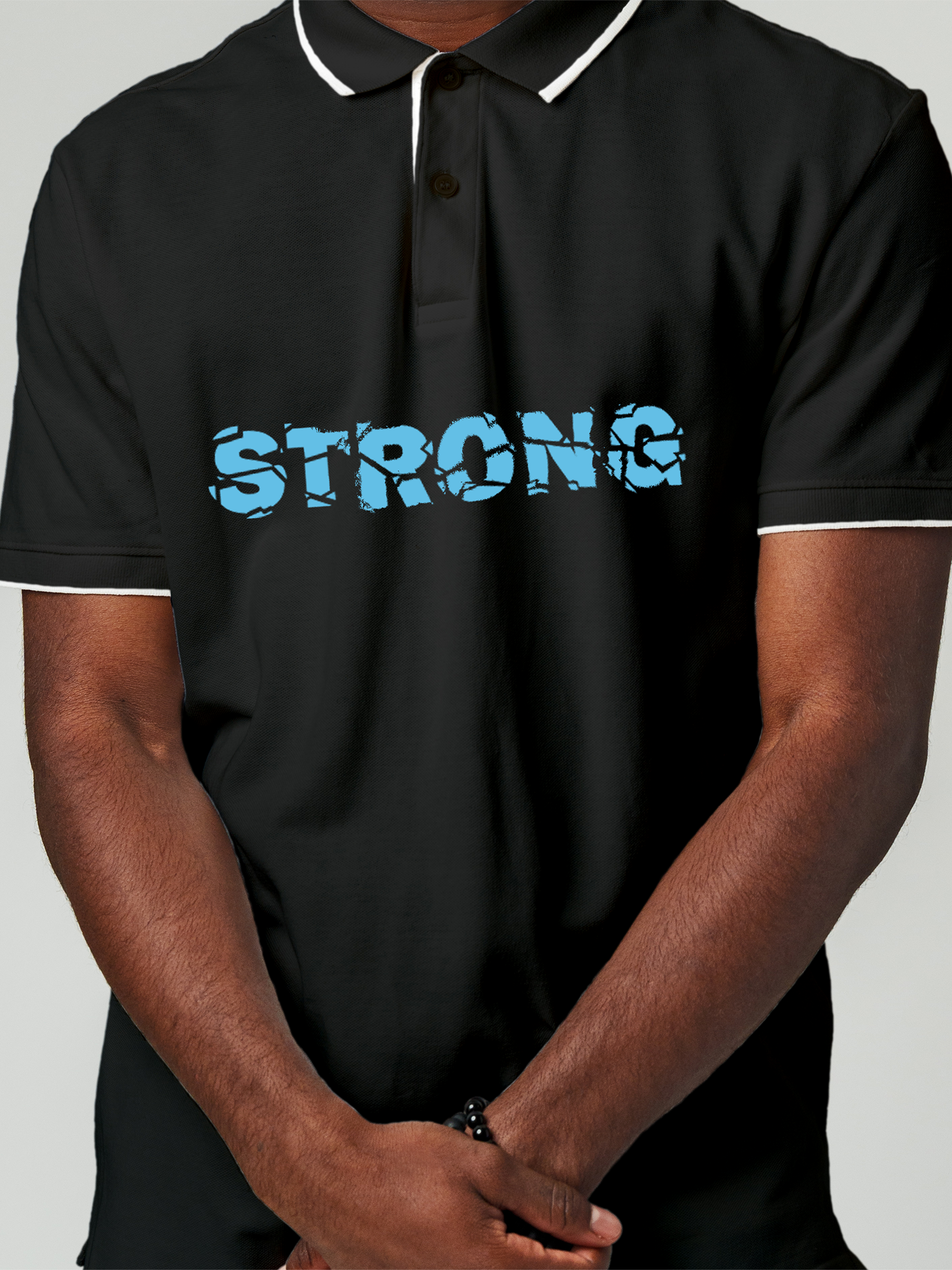 Close up of 'Strong' design on Men's Charcoal Grey Polo T-shirt, highlighting intricate details and vibrant print.