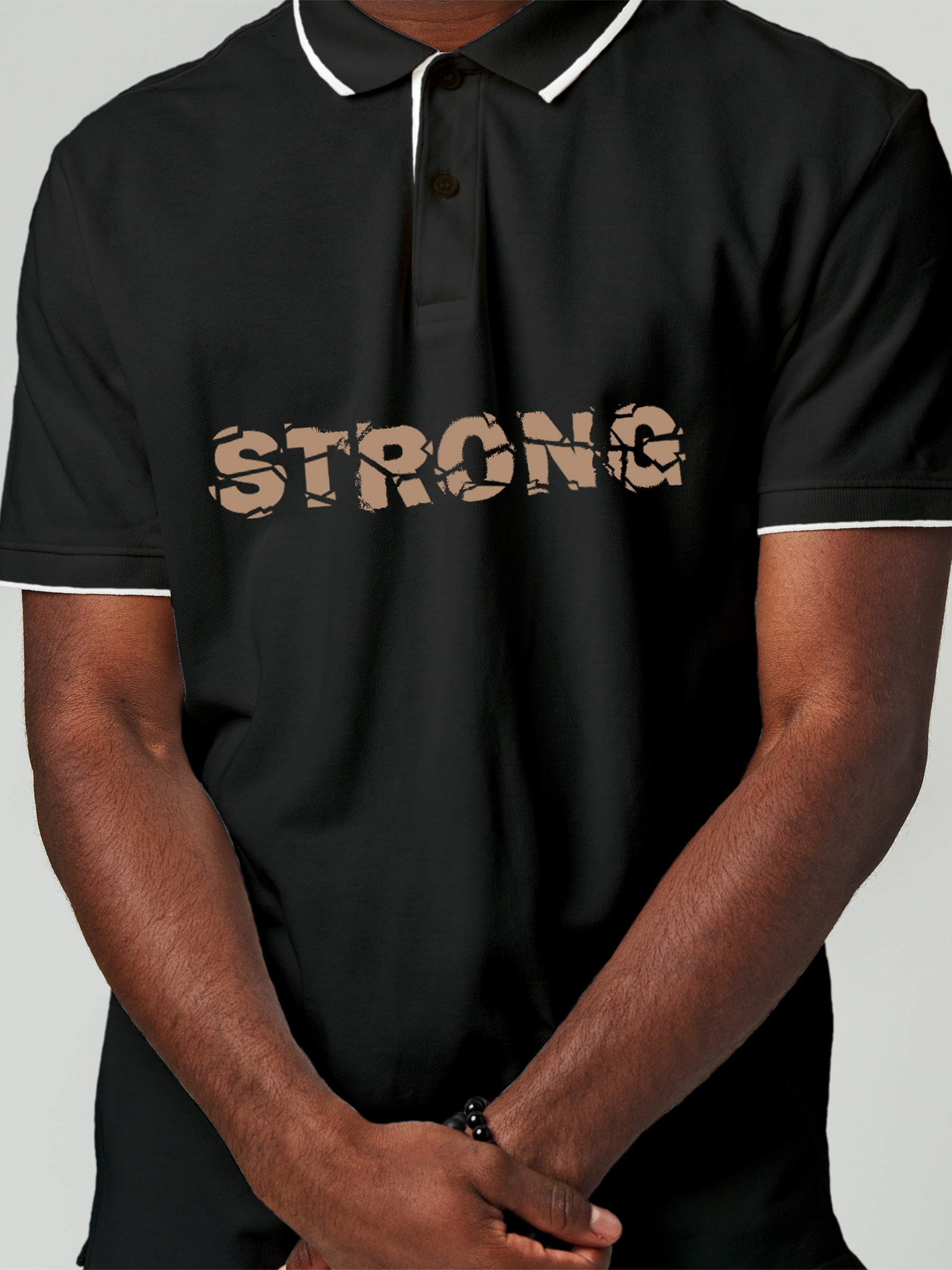 Close up of 'Strong' design on Men's Charcoal Grey Polo T-shirt, highlighting intricate details and vibrant print.