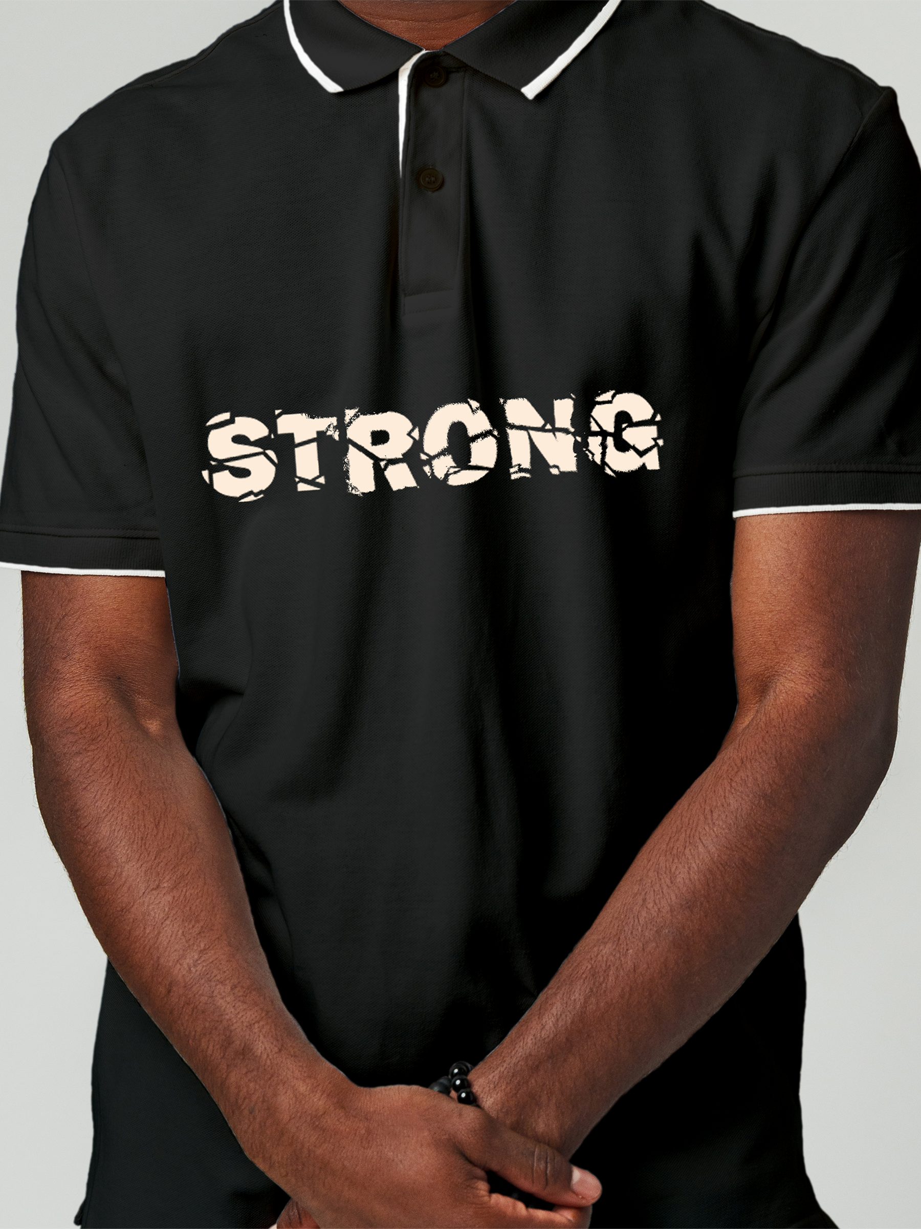 Close up of 'Strong' design on Men's Charcoal Grey Polo T-shirt, highlighting intricate details and vibrant print.