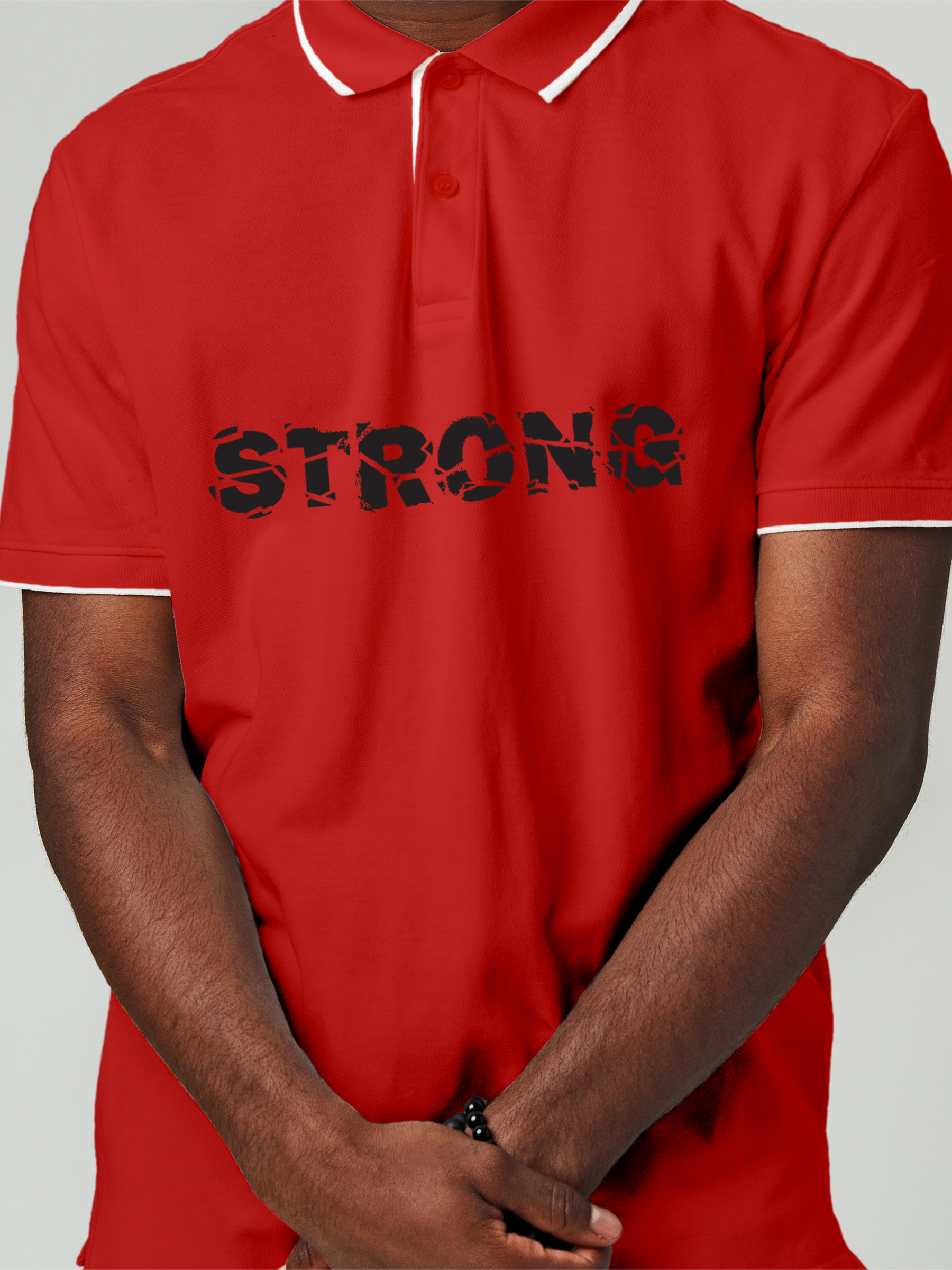 Close up of 'Strong' design on Men's Red Polo T-shirt, highlighting intricate details and vibrant print.