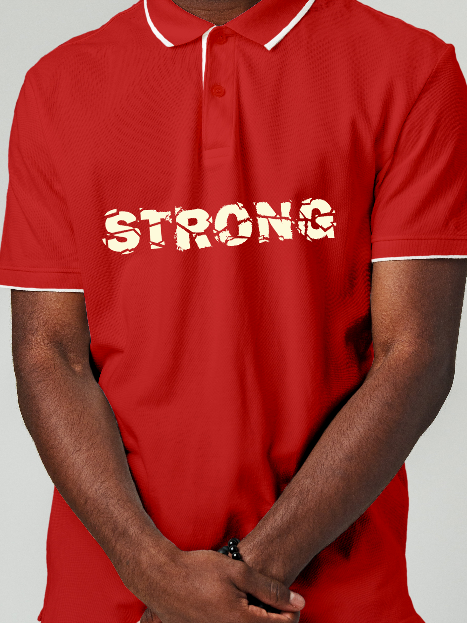 Close up of 'Strong' design on Men's Red Polo T-shirt, highlighting intricate details and vibrant print.