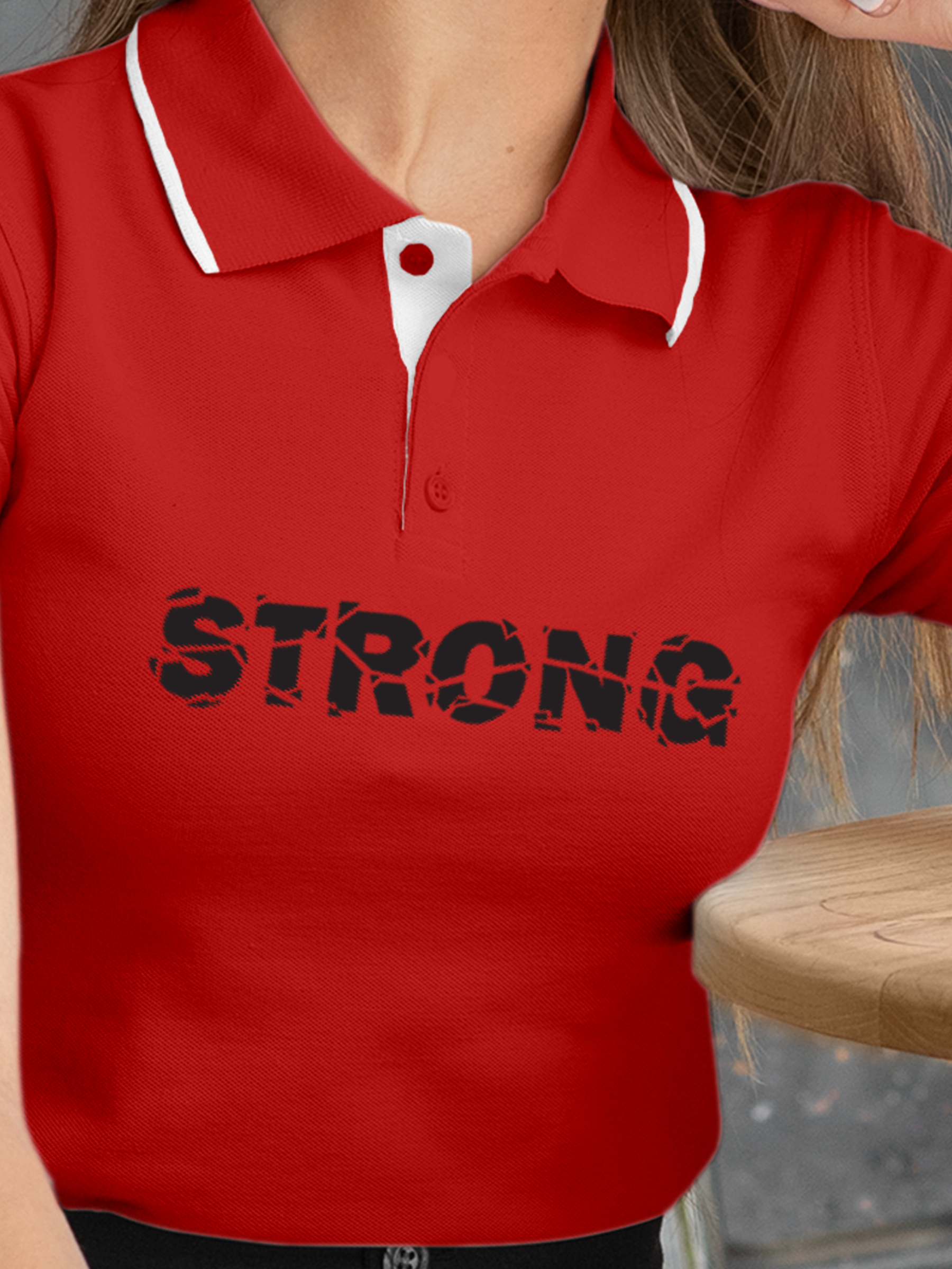 Close up of 'Strong' design on Women's Red Polo T-shirt, highlighting intricate details and vibrant print.