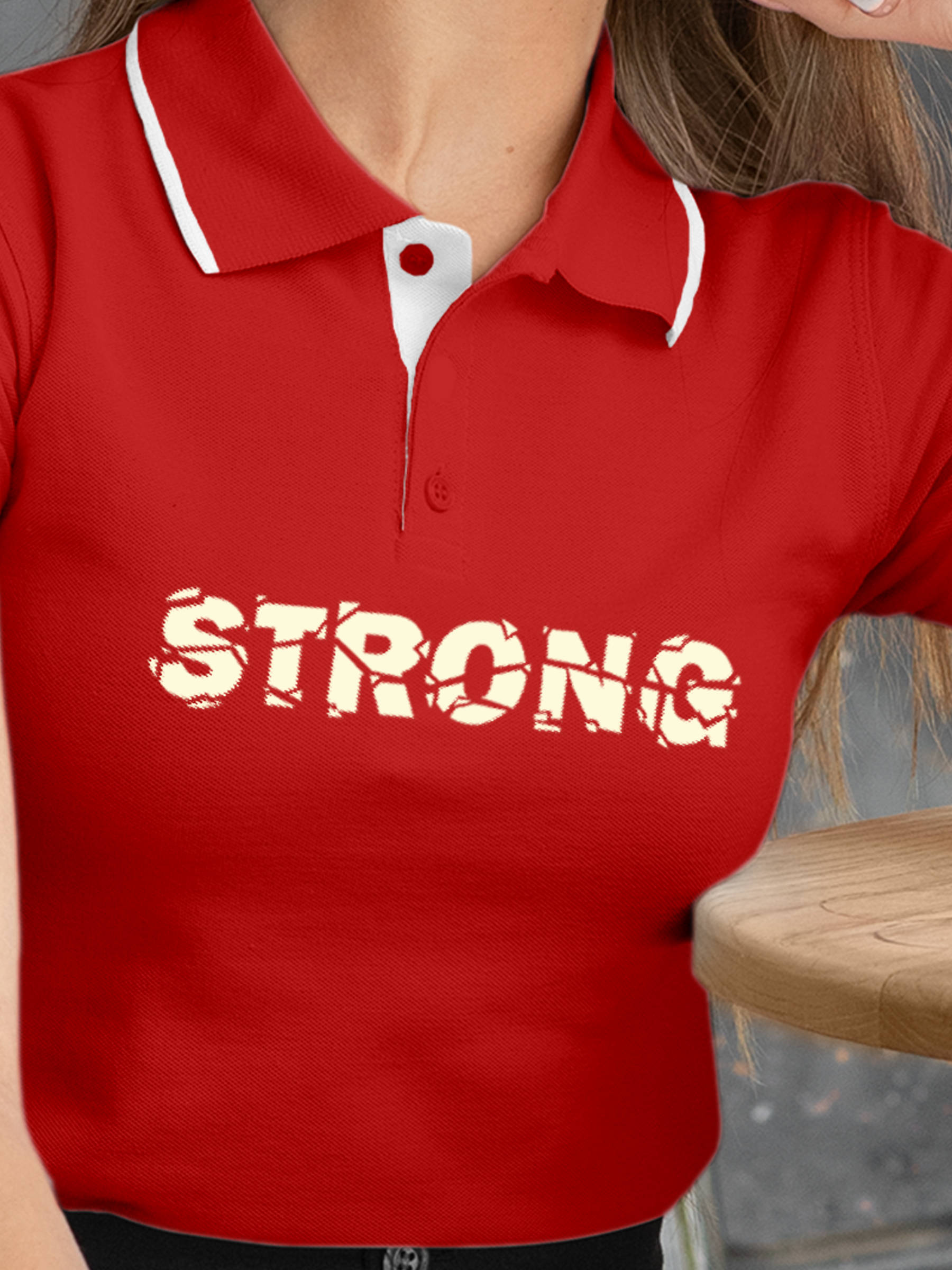 Close up of 'Strong' design on Women's Red Polo T-shirt, highlighting intricate details and vibrant print.