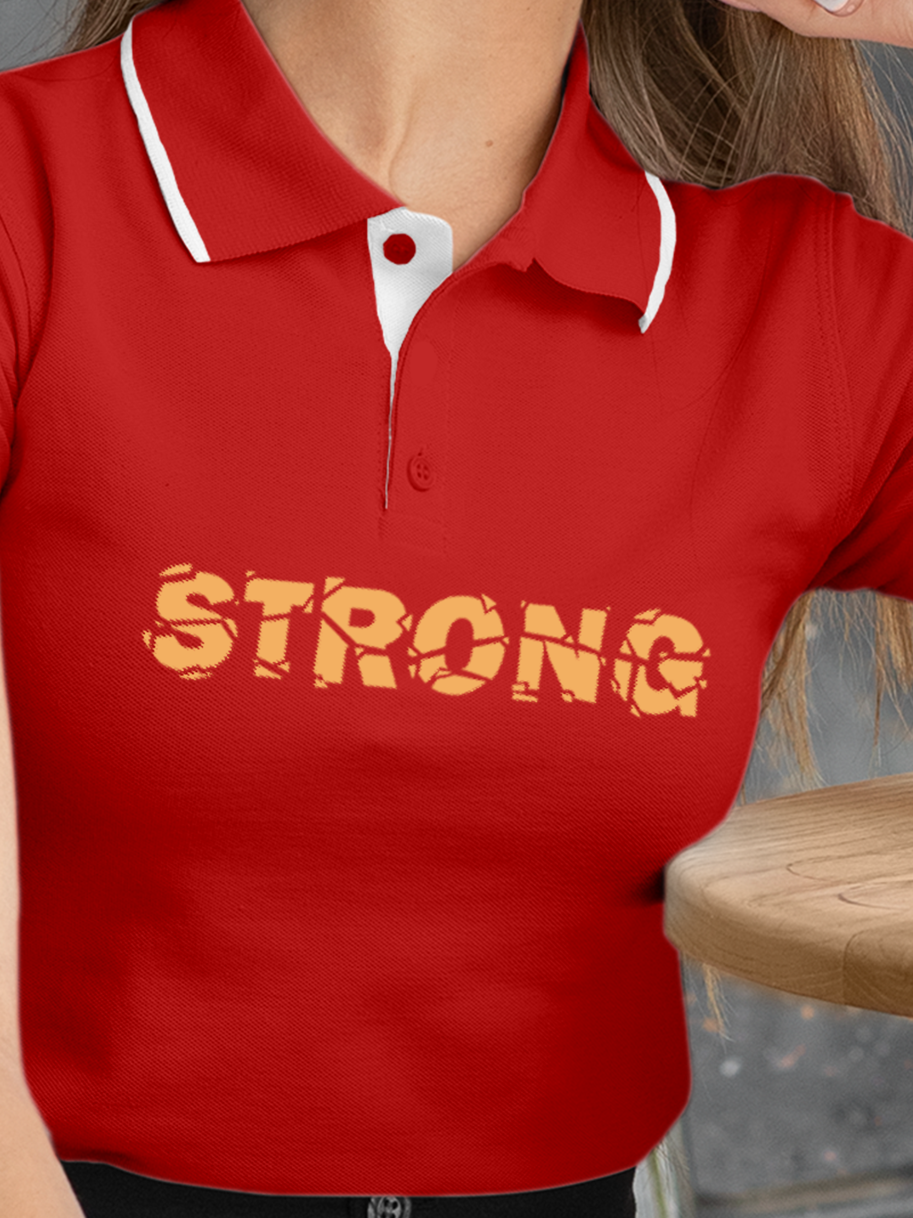 Close up of 'Strong' design on Women's Red Polo T-shirt, highlighting intricate details and vibrant print.