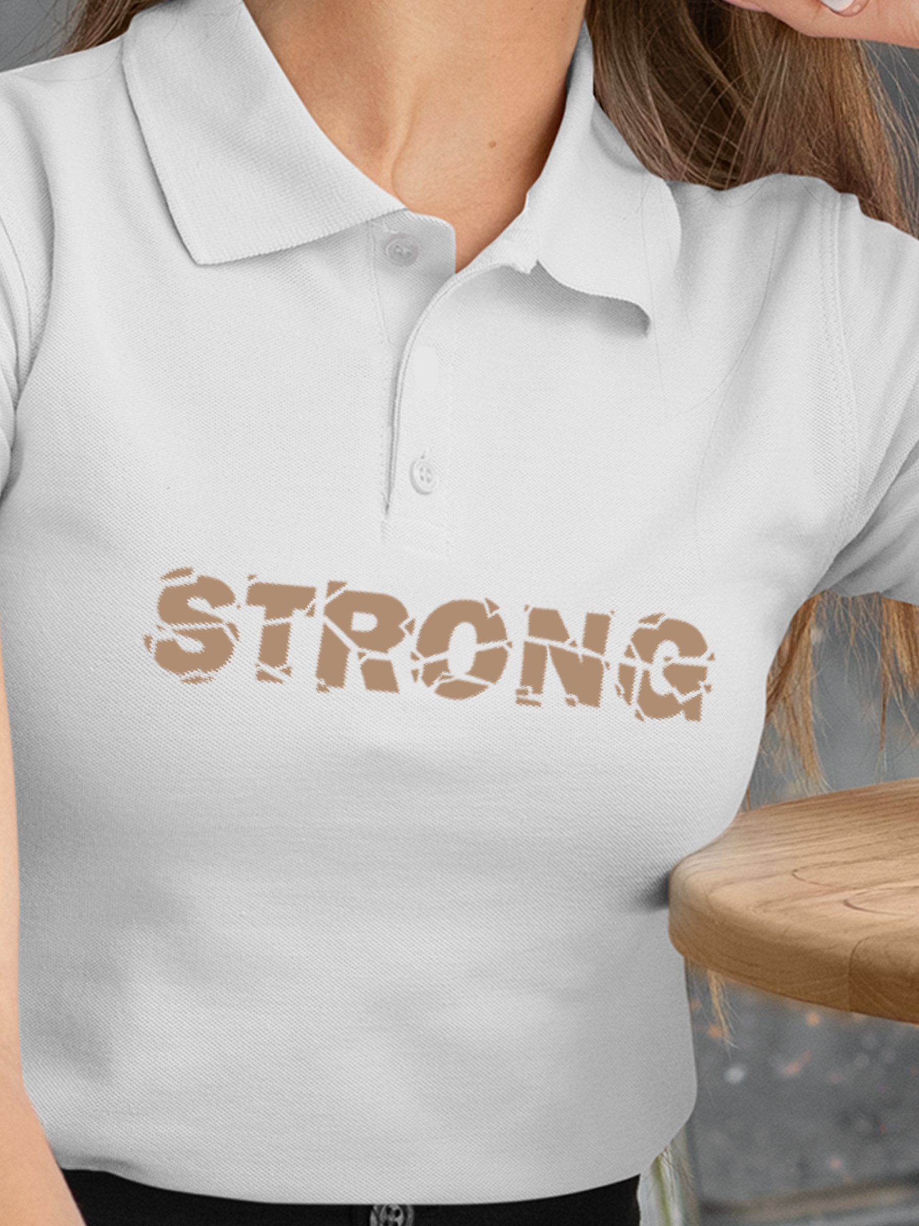Close up of 'Strong' design on Women's White Polo T-shirt, highlighting intricate details and vibrant print.