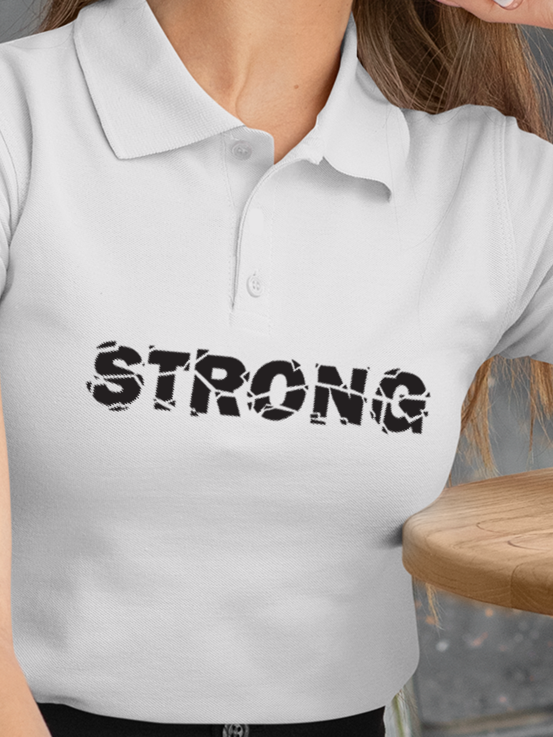 Close up of 'Strong' design on Women's White Polo T-shirt, highlighting intricate details and vibrant print.