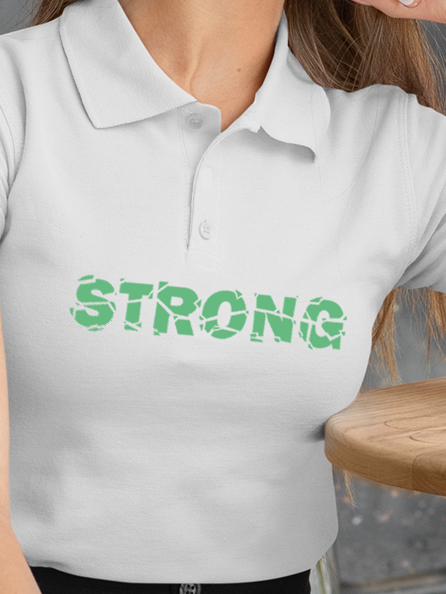 Close up of 'Strong' design on Women's White Polo T-shirt, highlighting intricate details and vibrant print.