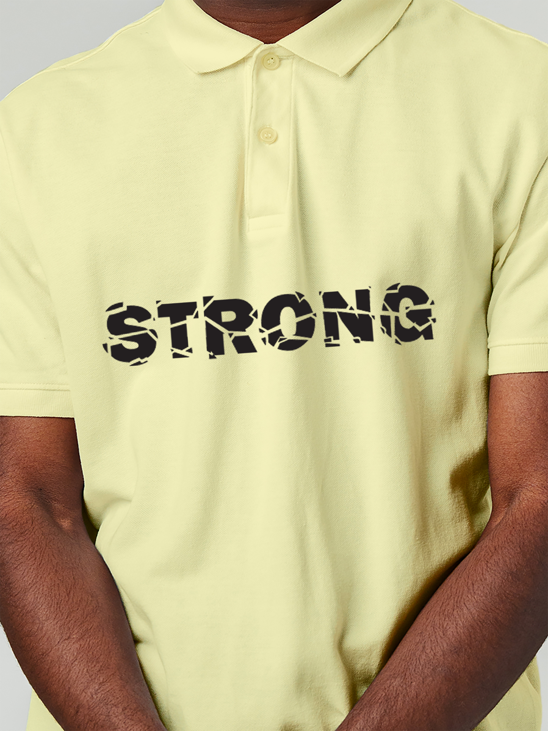 Close up of 'Strong' design on Men's Yellow Polo T-shirt, highlighting intricate details and vibrant print.