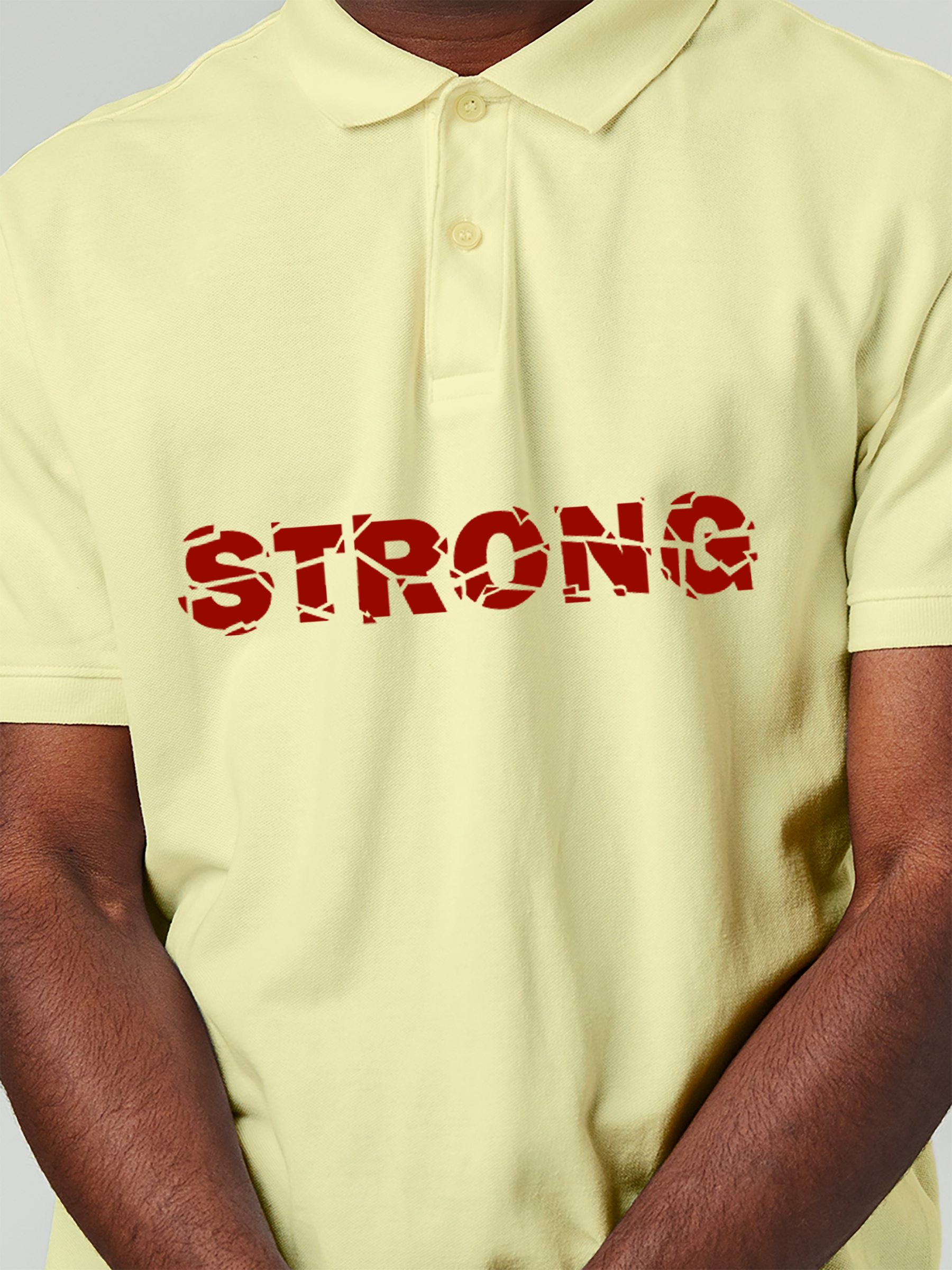 Close up of 'Strong' design on Men's Yellow Polo T-shirt, highlighting intricate details and vibrant print.