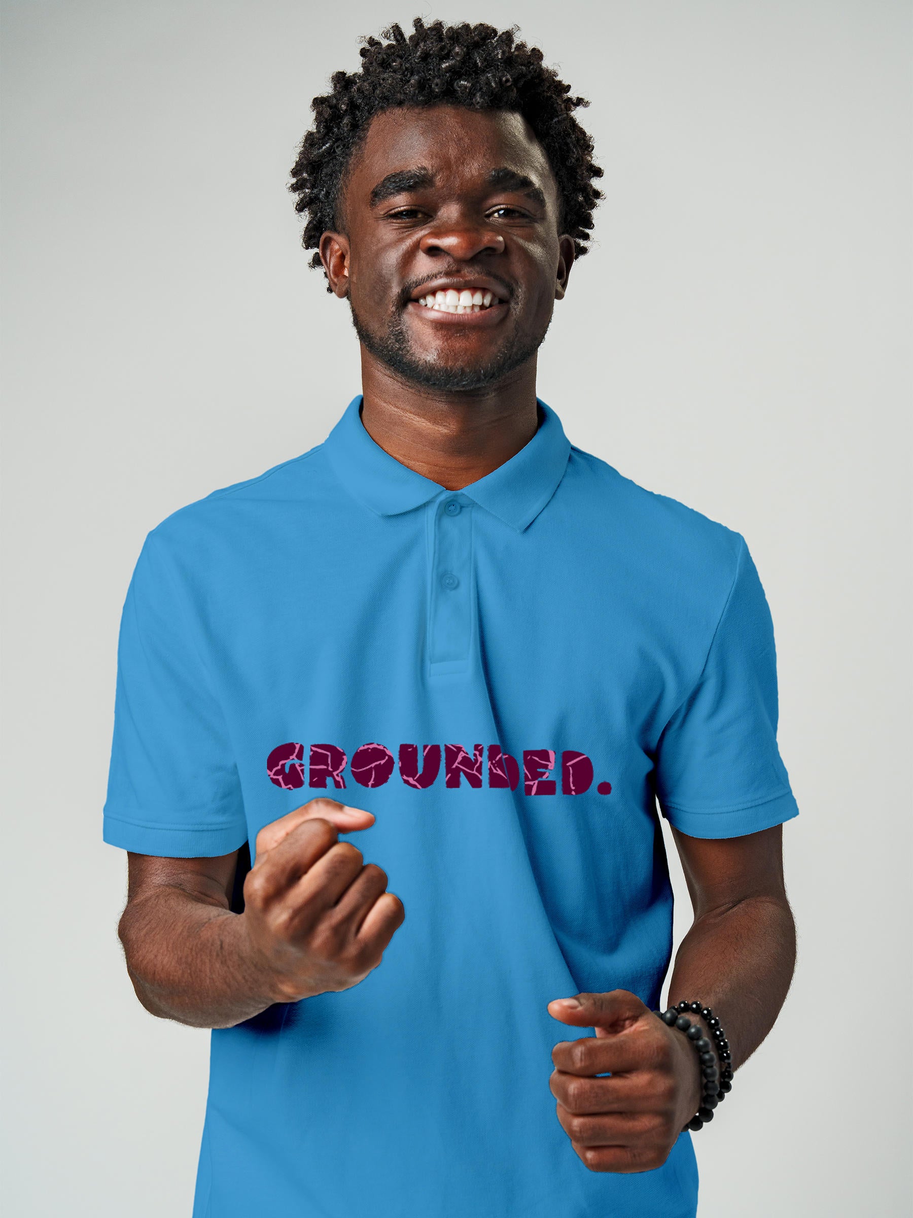 Model wearing Men's Blue Polo T-shirt with 'Grounded' design, offering effortless style and premium comfort