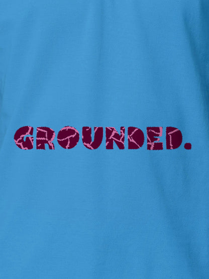 Close up of 'Grounded' design on Men's Blue Polo T-shirt, highlighting intricate details and vibrant print.