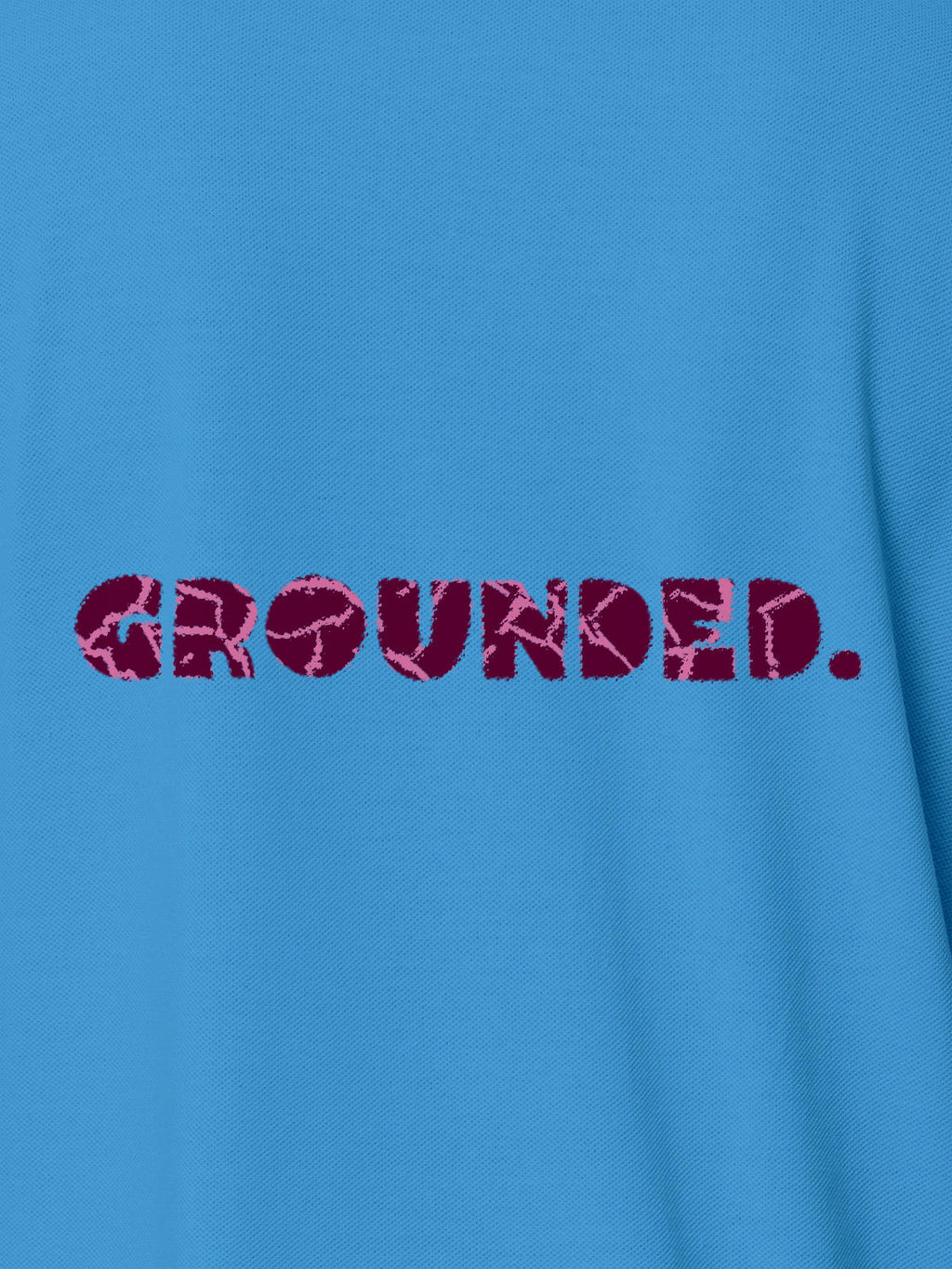 Close up of 'Grounded' design on Women's Blue Polo T-shirt, highlighting intricate details and vibrant print.