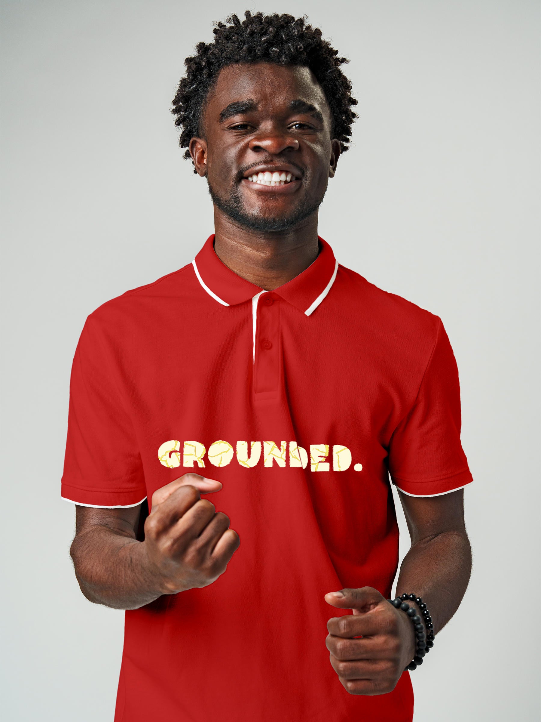 Model wearing Men's Red Polo T-shirt with 'Grounded' design, offering effortless style and premium comfort