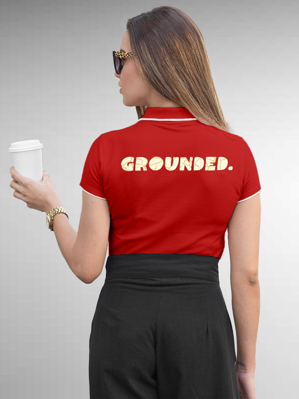 Model wearing Women's Red Polo T-shirt with 'Grounded' design, offering effortless style and premium comfort