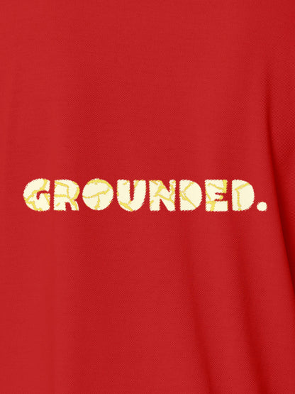 Close up of 'Grounded' design on Women's Red Polo T-shirt, highlighting intricate details and vibrant print.