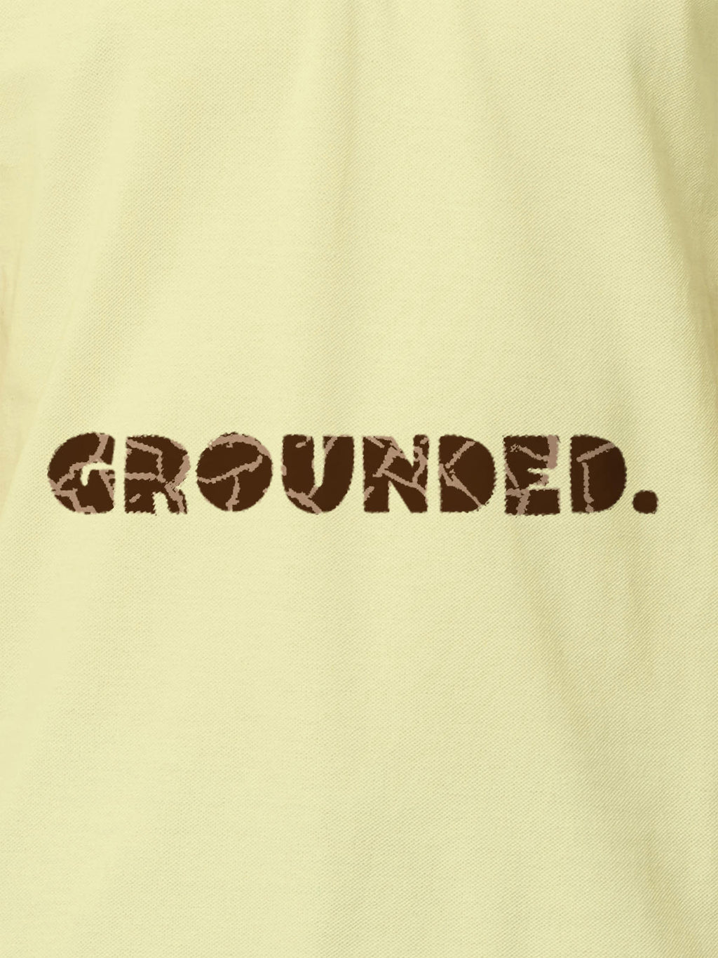 Close up of 'Grounded' design on Men's Yellow Polo T-shirt, highlighting intricate details and vibrant print.