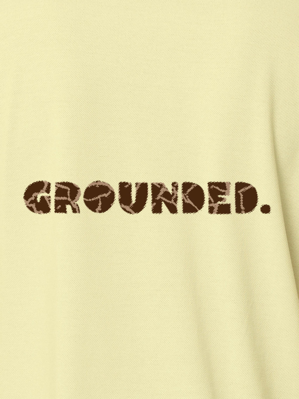 Close up of 'Grounded' design on Women's Yellow Polo T-shirt, highlighting intricate details and vibrant print.