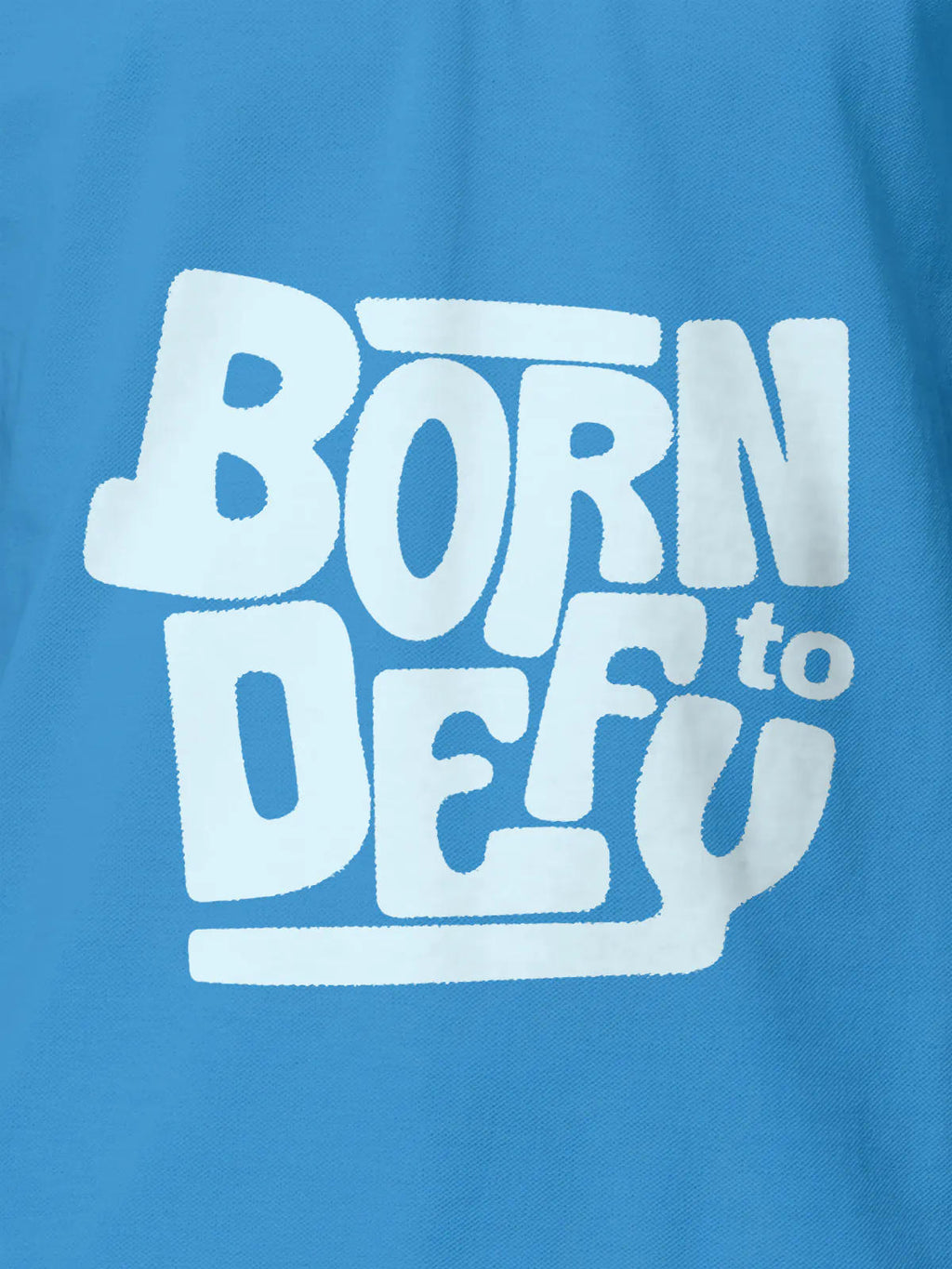 Close up of 'Born To Defy' design on Men's Blue Polo T-shirt, highlighting intricate details and vibrant print.