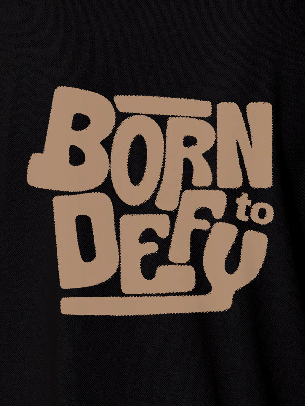 Close up of 'Born To Defy' design on Women's Black Polo T-shirt, highlighting intricate details and vibrant print.