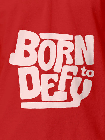 Close up of 'Born To Defy' design on Men's Red Polo T-shirt, highlighting intricate details and vibrant print.
