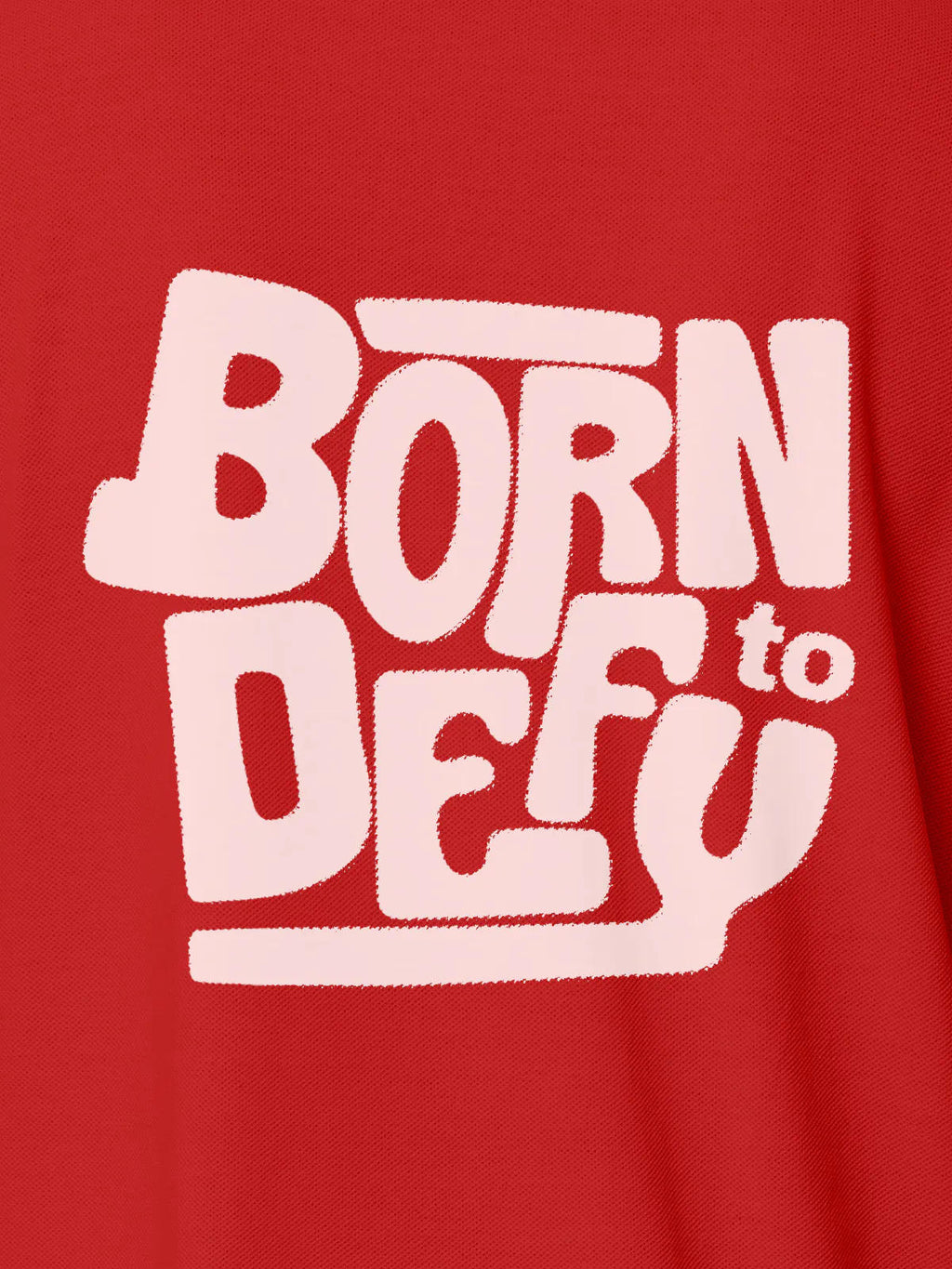 Close up of 'Born To Defy' design on Women's Red Polo T-shirt, highlighting intricate details and vibrant print.