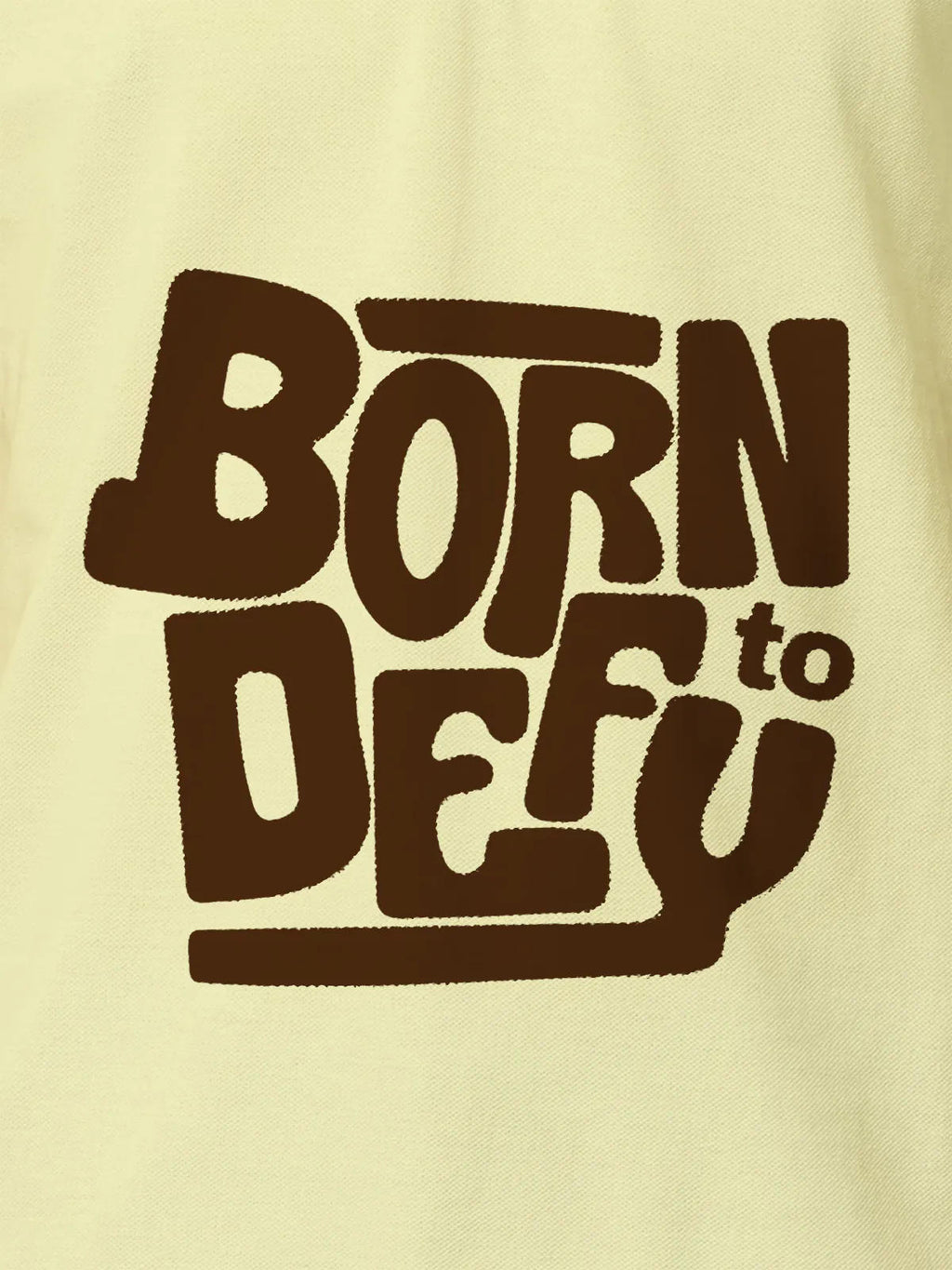 Close up of 'Born To Defy' design on Men's Yellow Polo T-shirt, highlighting intricate details and vibrant print.