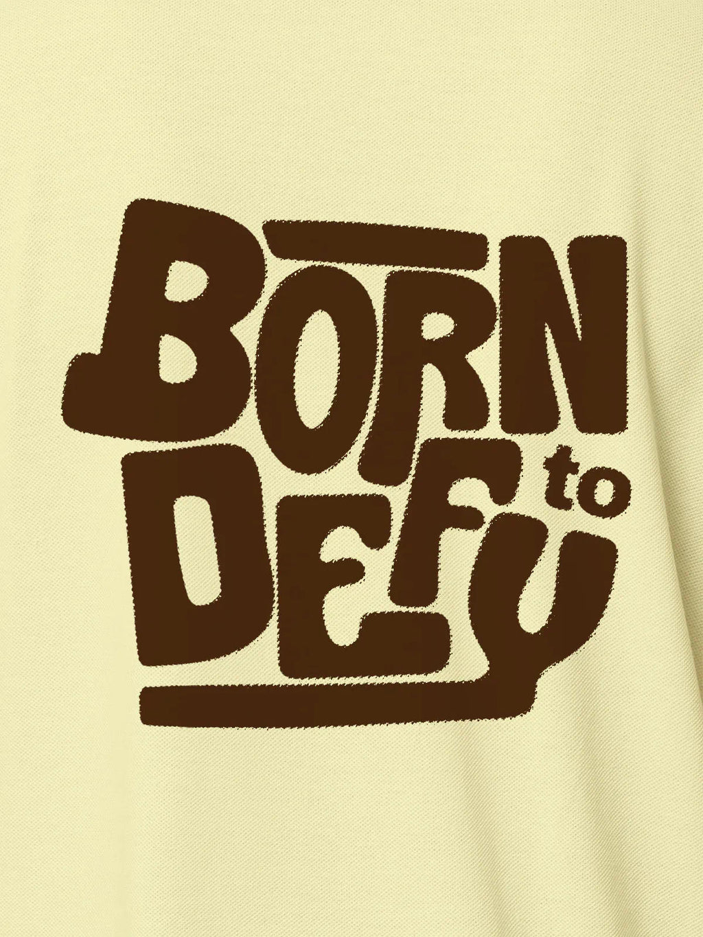 Close up of 'Born To Defy' design on Women's Yellow Polo T-shirt, highlighting intricate details and vibrant print.