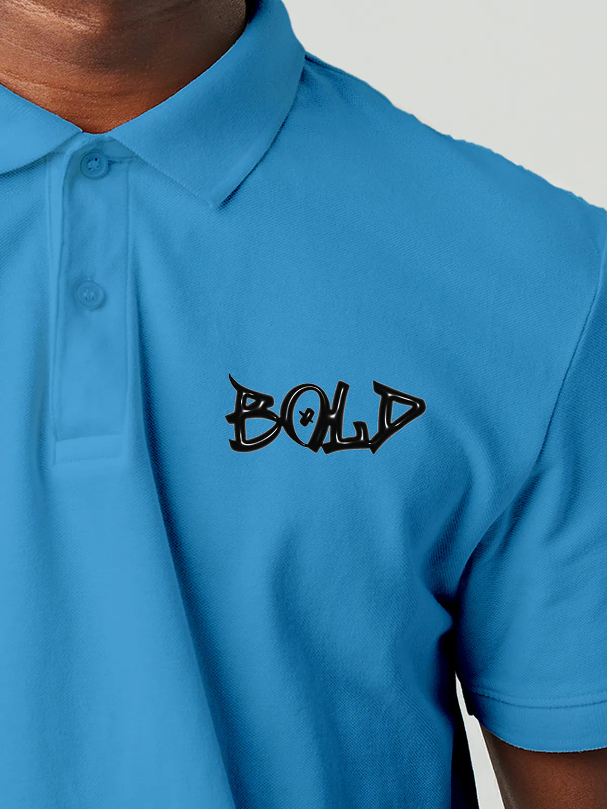 Close up of 'Bold' on Men's Blue Polo T-shirt, highlighting intricate details and vibrant print.