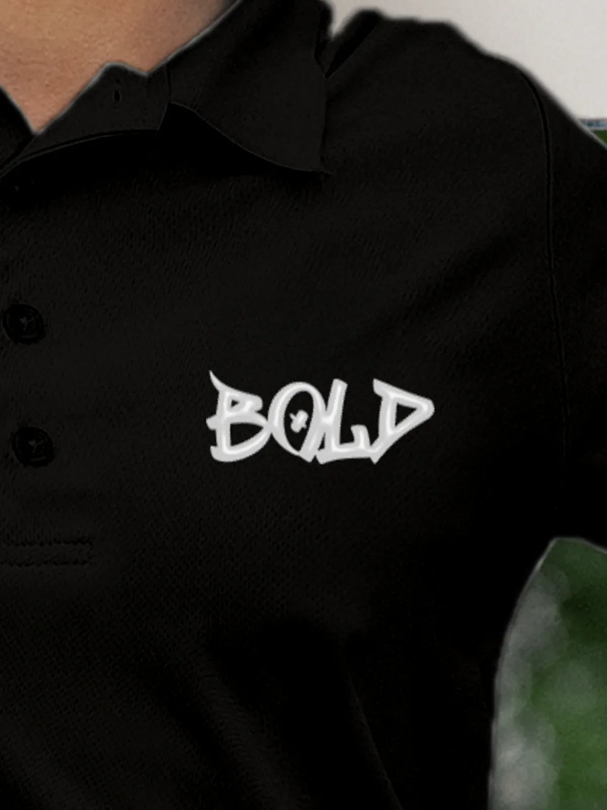 Close up of 'Bold' on Women's Black Polo T-shirt, highlighting intricate details and vibrant print.