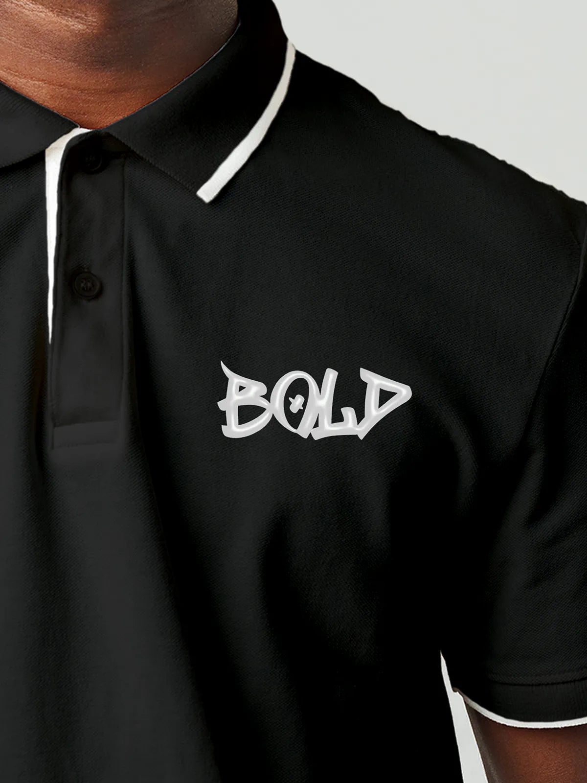 Close up of 'Bold' on Men's Dark Grey Polo T-shirt, highlighting intricate details and vibrant print.