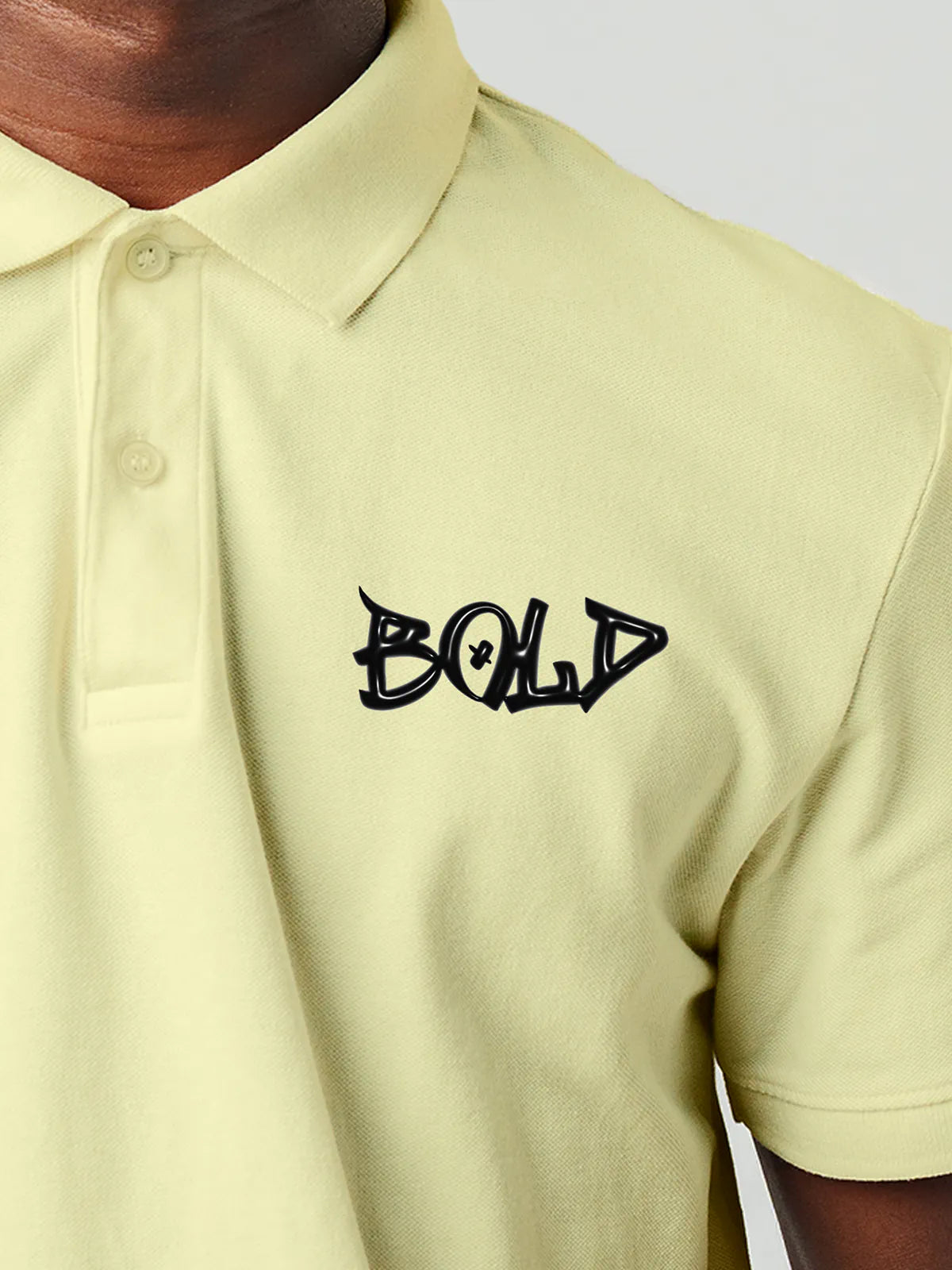 Close up of 'Bold' on Men's Yellow Polo T-shirt, highlighting intricate details and vibrant print.