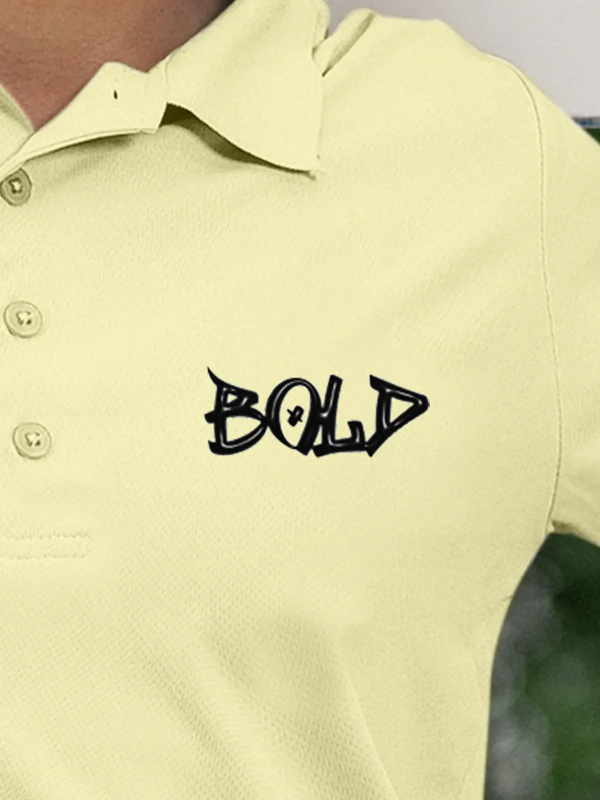 Close up of 'Bold' on Women's Yellow Polo T-shirt, highlighting intricate details and vibrant print.