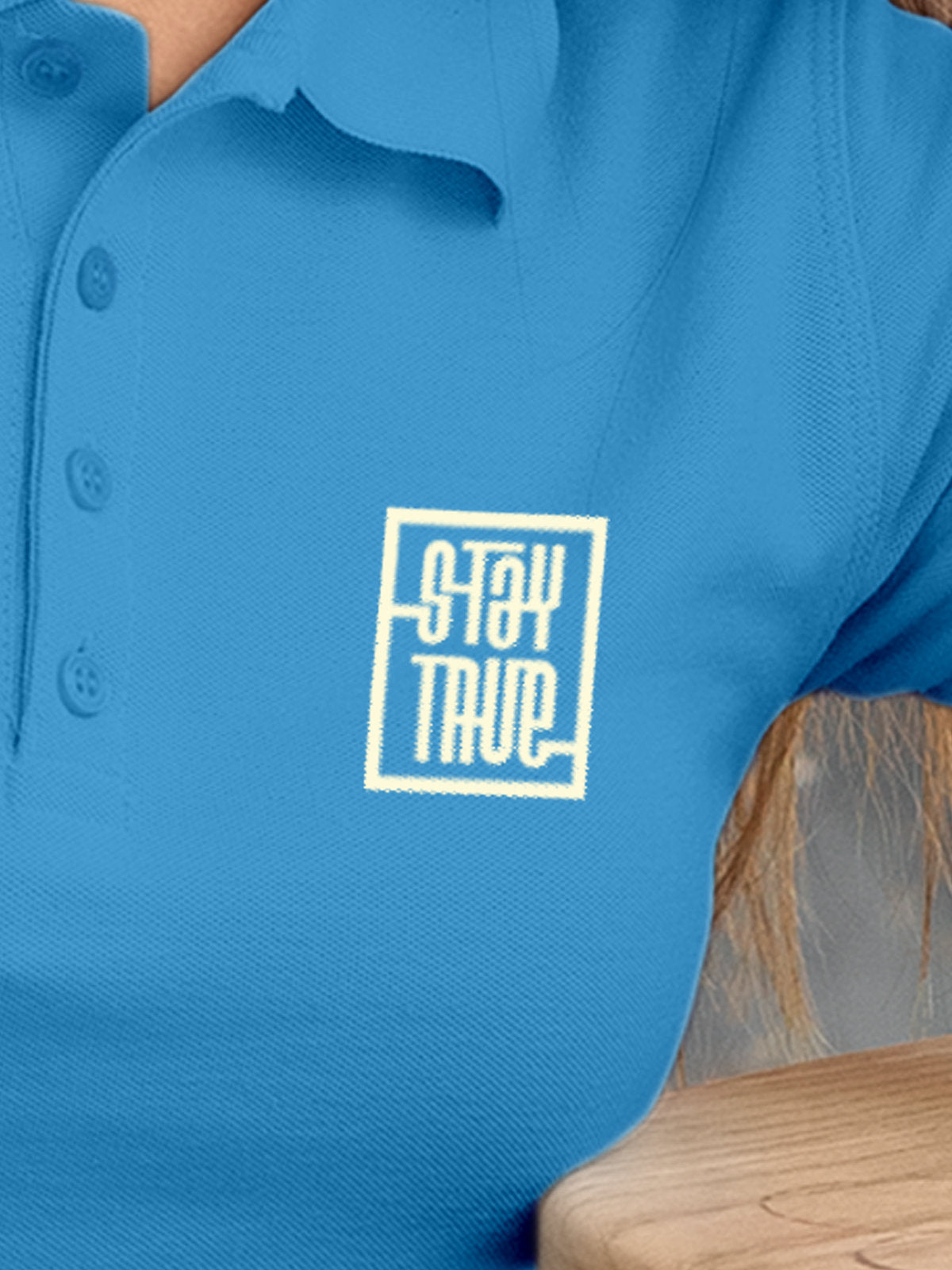 Close up of 'Stay True' on Women's Blue Polo T-shirt, highlighting intricate details and vibrant print.