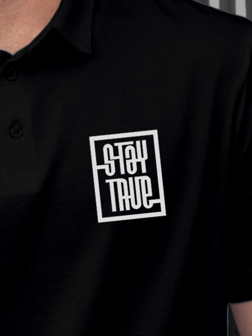 Close up of 'Stay True' design on Men's Black Polo T-shirt, highlighting intricate details and vibrant print.