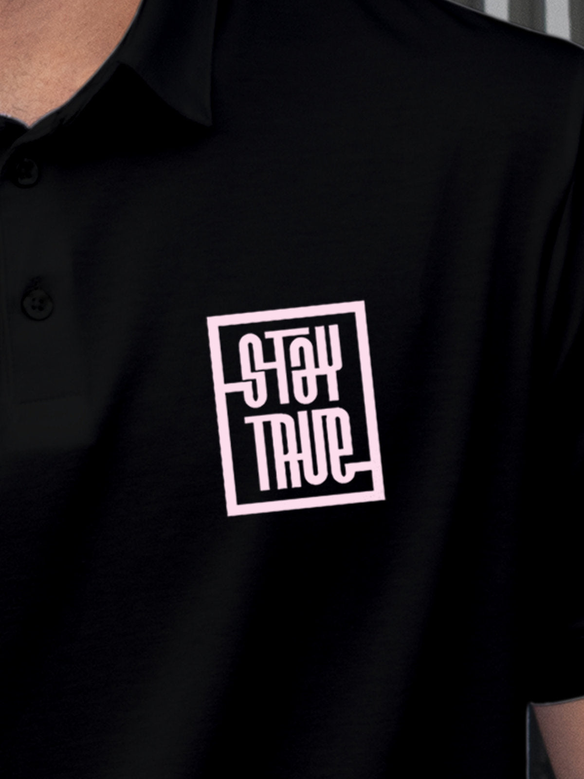 Close up of 'Stay True' on Men's Black Polo T-shirt, highlighting intricate details and vibrant print.