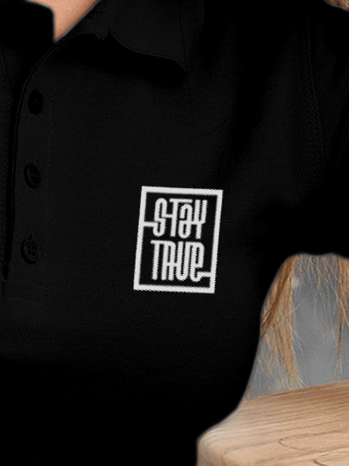 Close up of 'Stay True' on Women's Black Polo T-shirt, highlighting intricate details and vibrant print.