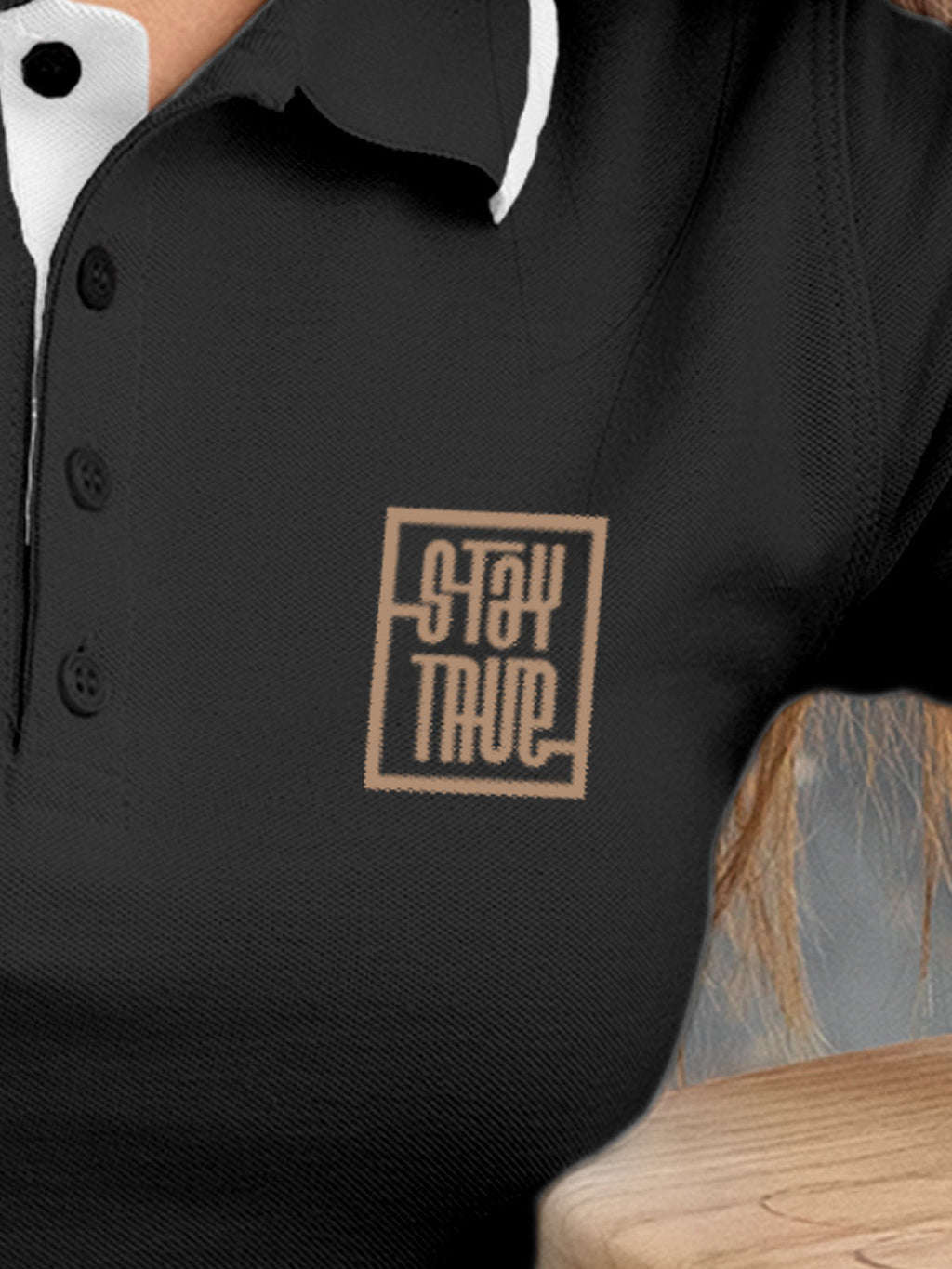 Close up of 'Stay True' design on Women's Dark Grey Polo T-shirt, highlighting intricate details and vibrant print.