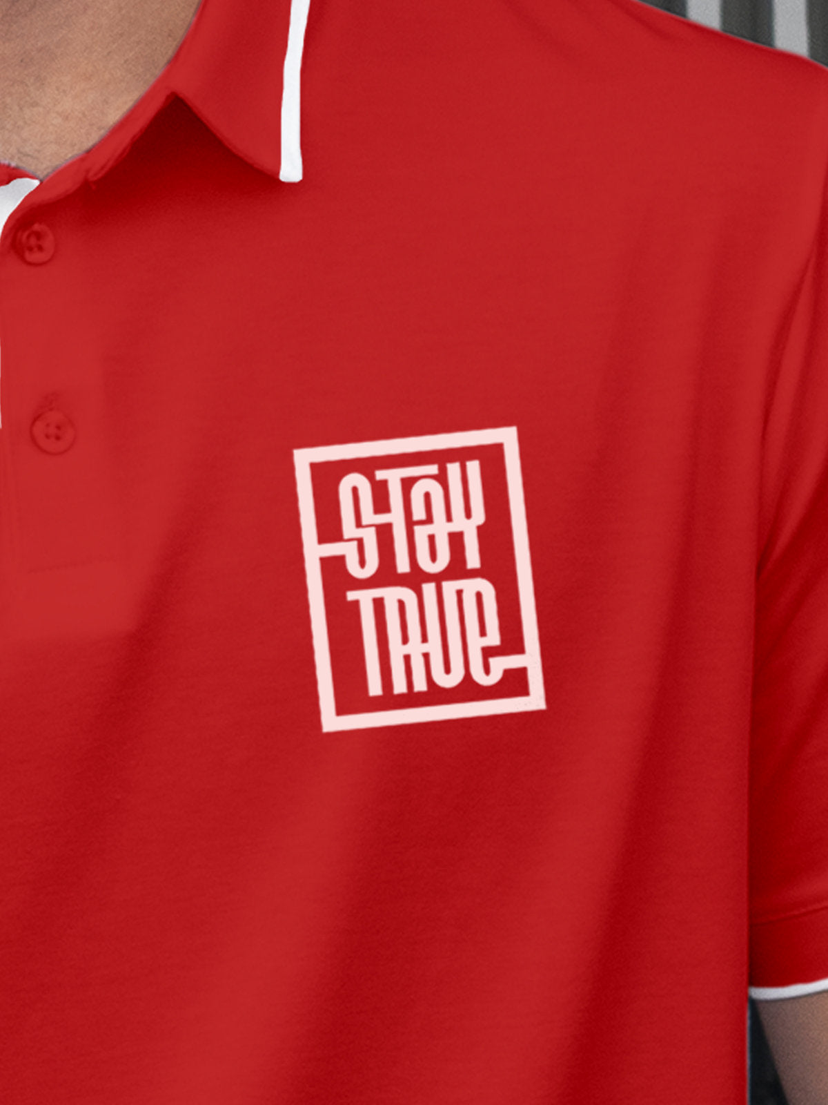 Close up of 'Stay True' on Men's Red Polo T-shirt, highlighting intricate details and vibrant print.