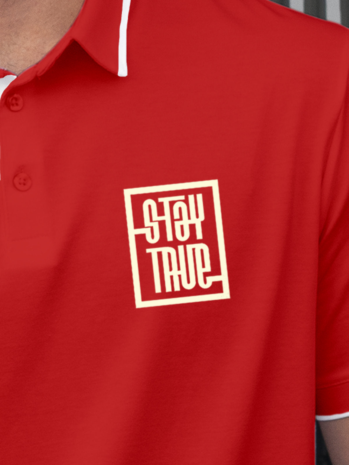 Close up of 'Stay True' on Men's Red Polo T-shirt, highlighting intricate details and vibrant print.